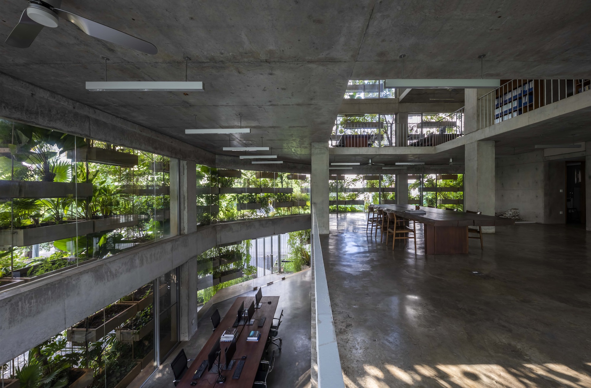 Upper floor workspace with polished concrete floor and views to planted terraces and lower level