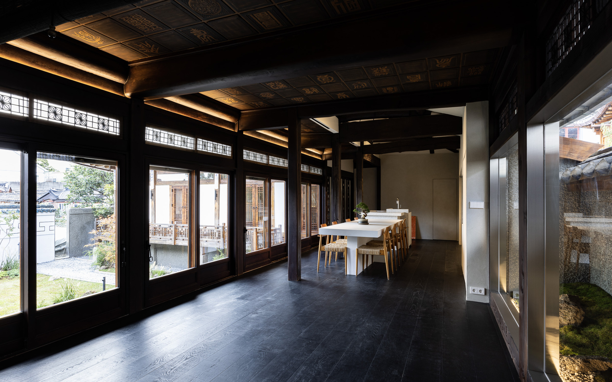 Dining room with coffered ceiling and latticed windows opening to the courtyard beyond