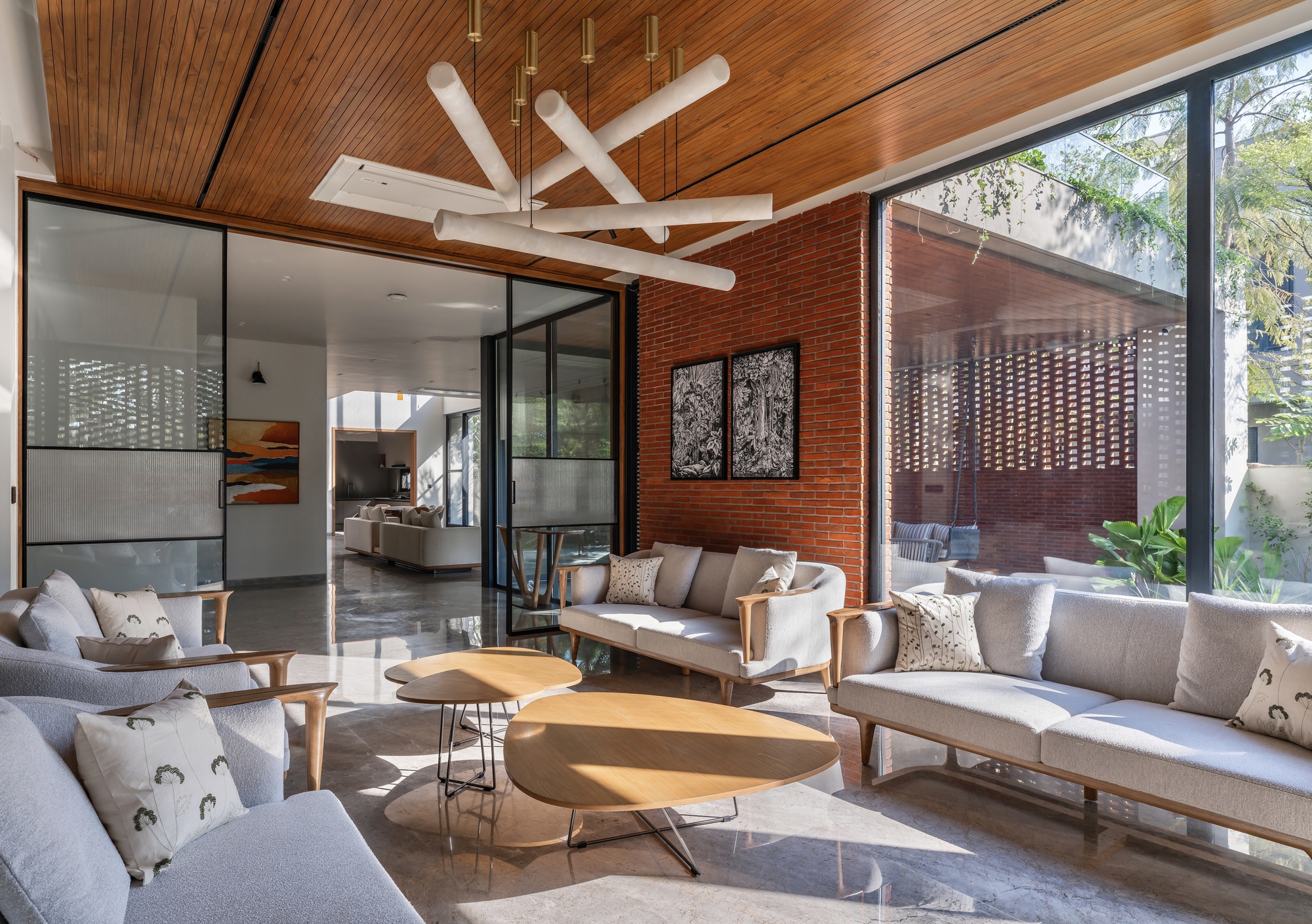 Seating area with sculptural white ceiling fixture beneath timber slats and warm afternoon sunlight
