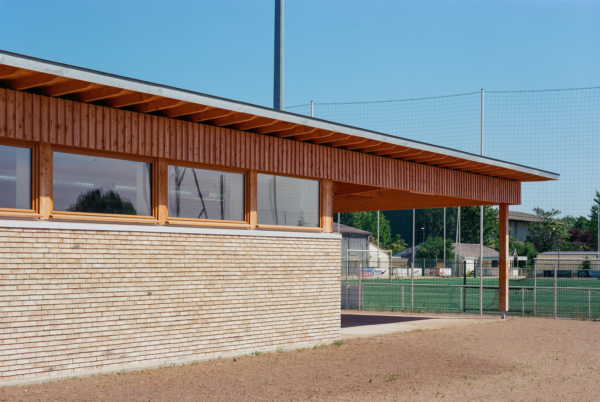 Horizontal timber siding below vertical wood cladding and a band of glazing with exposed rafter soffit