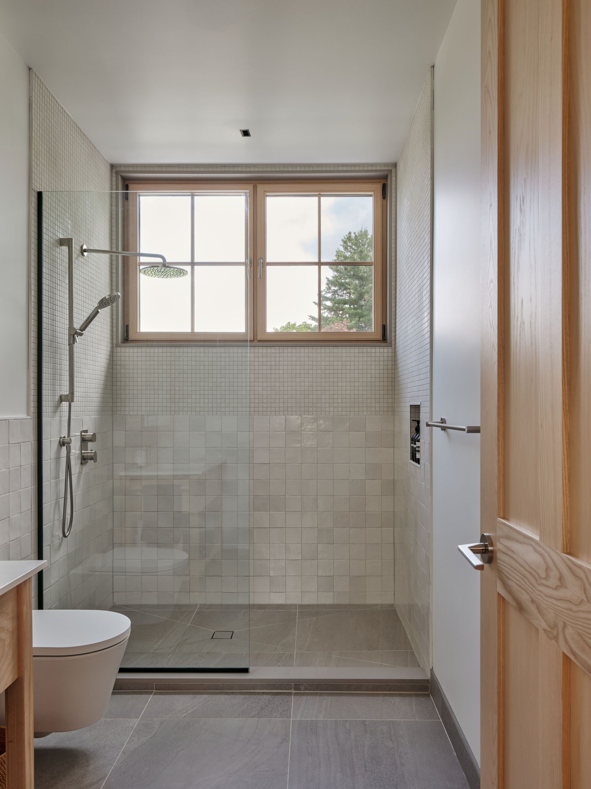 Bathroom with white square tile shower enclosure and timber-framed window above