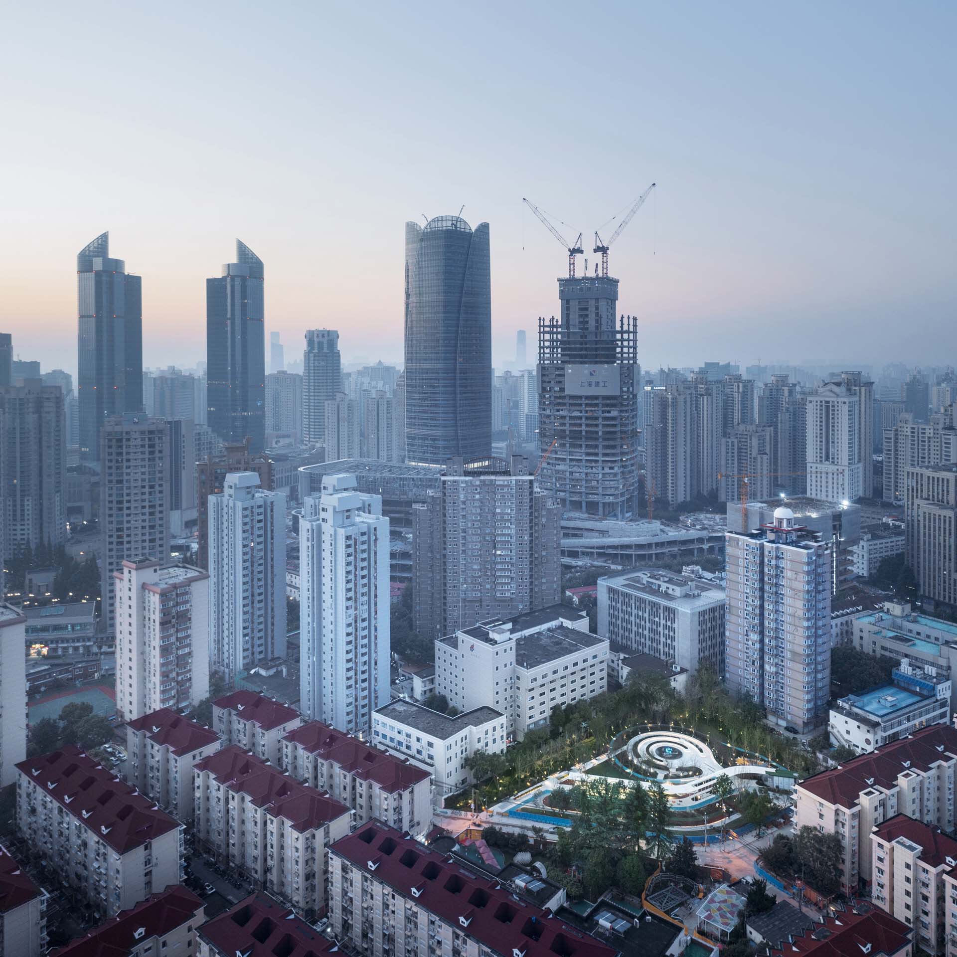 Aerial view of the curved roof canopy nestled among residential towers at dusk