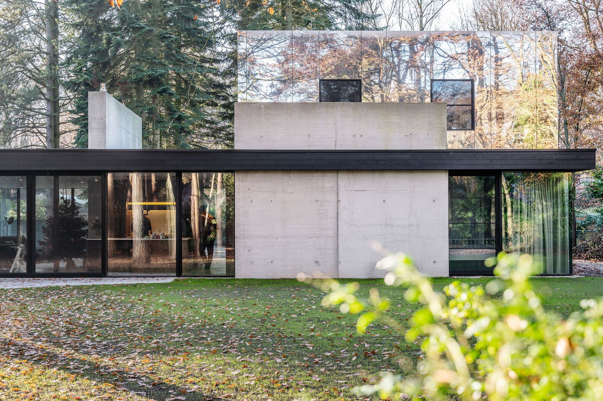 Garden facade showing stacked concrete volumes with dark horizontal banding and floor-to-ceiling glazing