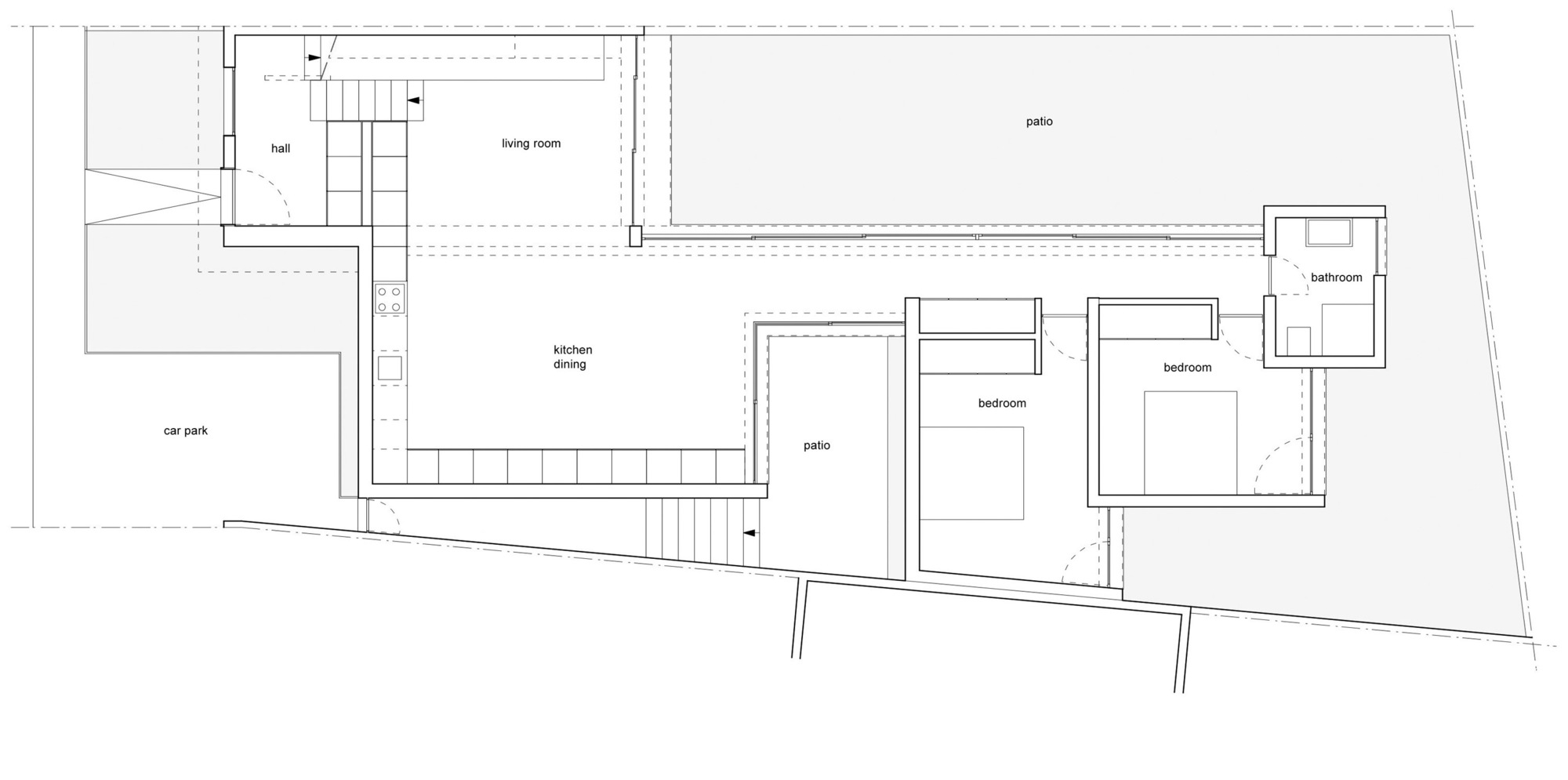 Floor plan showing living spaces arranged around two patio areas with adjacent car park