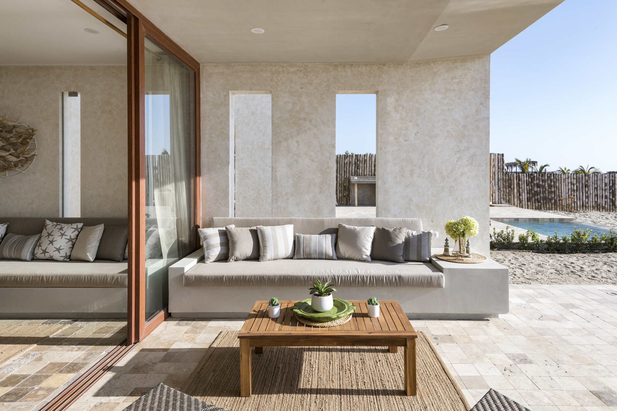 Covered outdoor terrace with built-in concrete seating and timber framed sliding doors opening to the interior