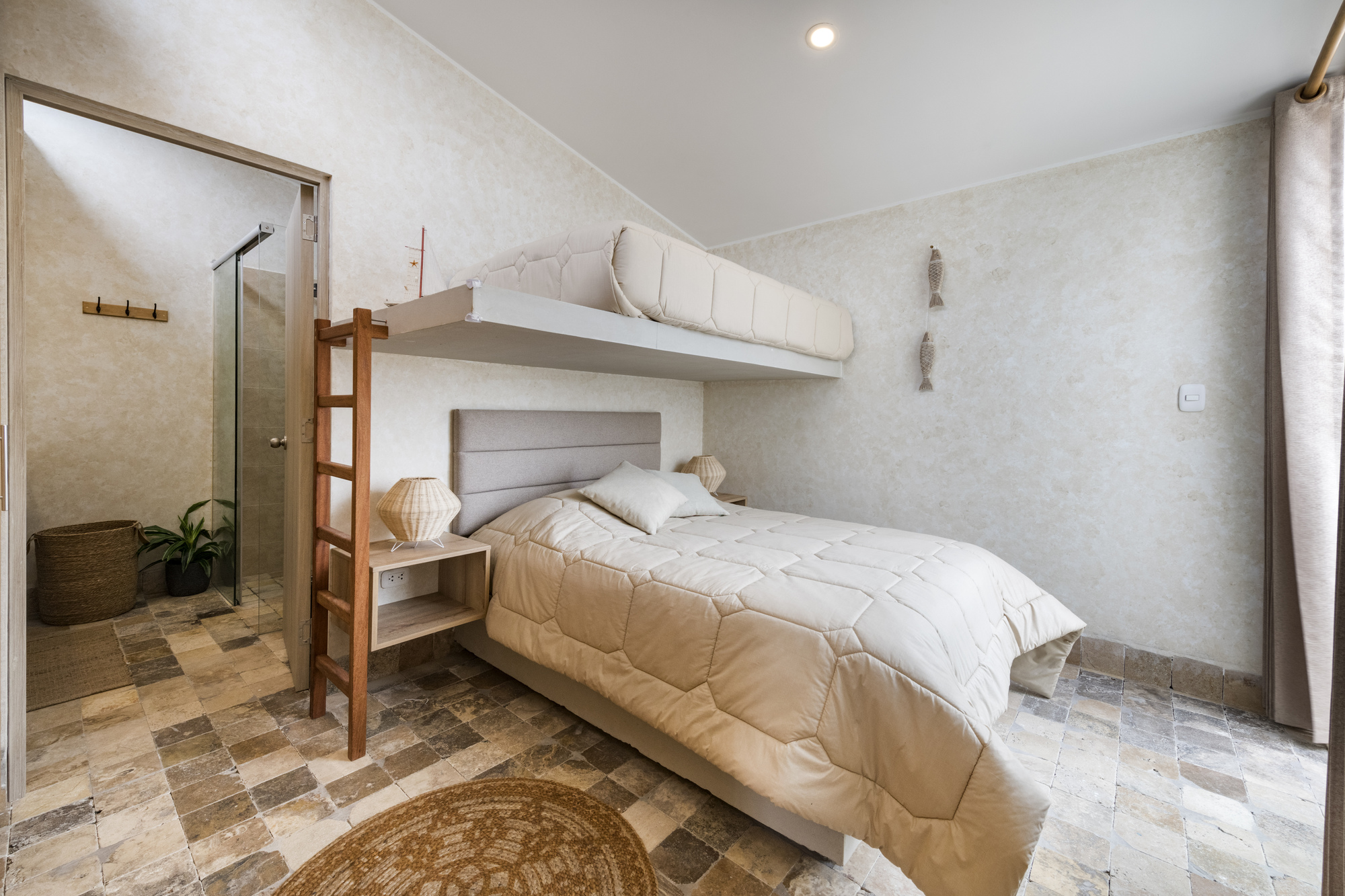 Bedroom with built-in bunk bed and ensuite bathroom visible through open timber-framed door