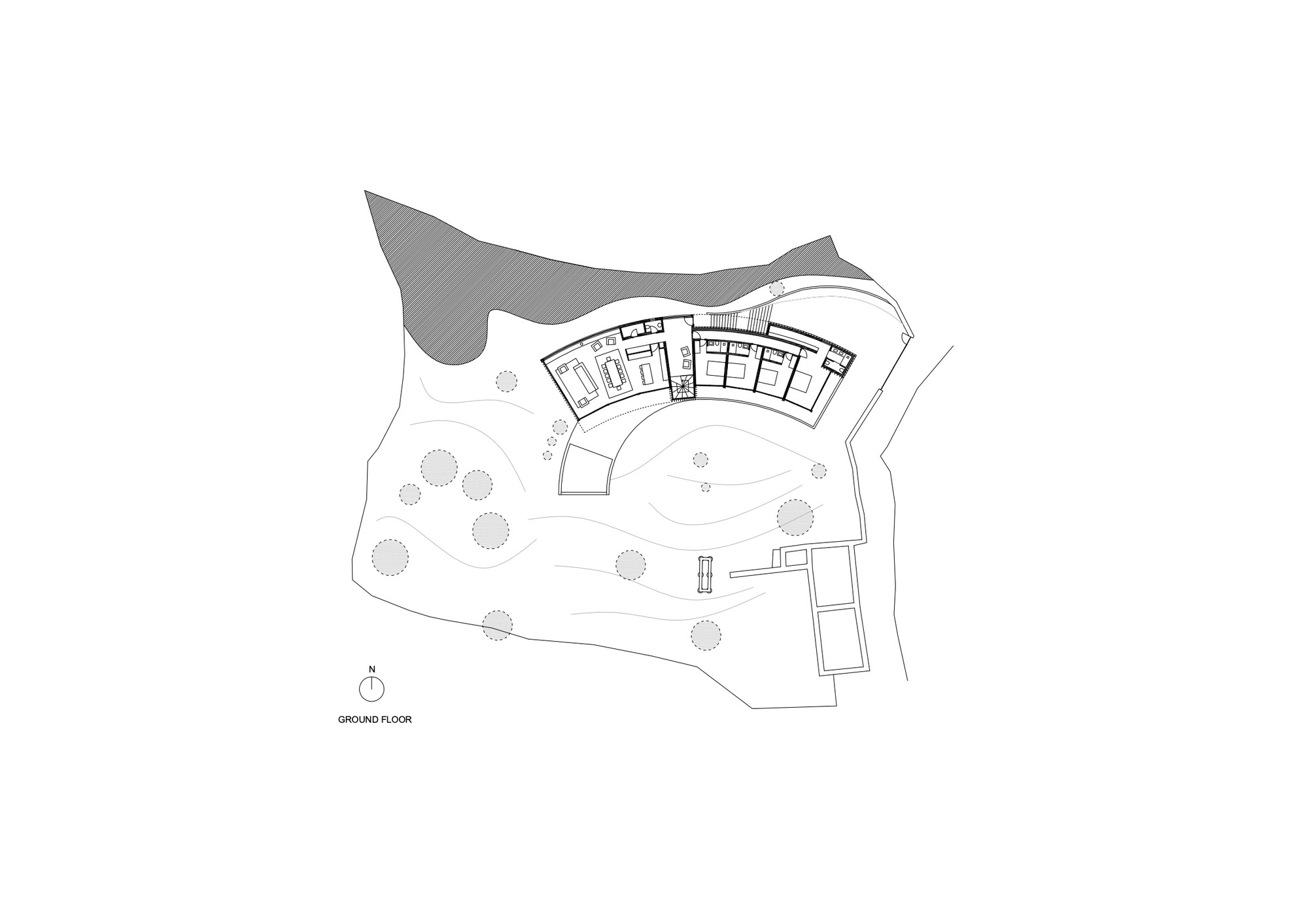 Ground floor plan showing curved volume with interior rooms and surrounding landscape with trees