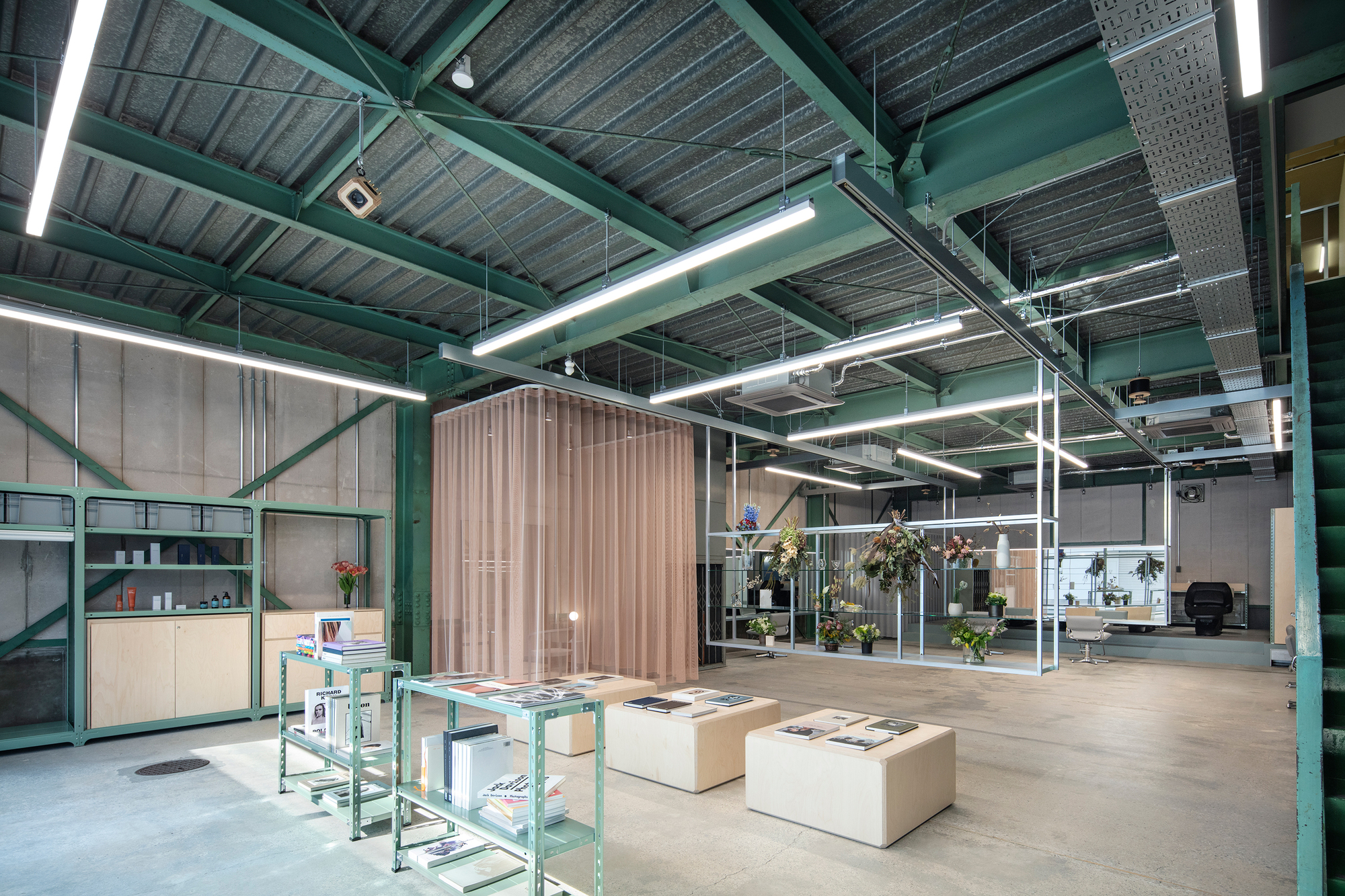 Office interior showing green metal shelving, cream seating blocks and tubular corrugated wood room divider