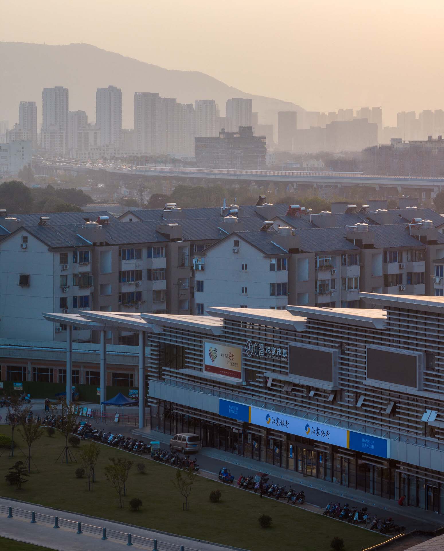Distant view of the horizontal louvered facade with mountains and hazy skyline at dawn
