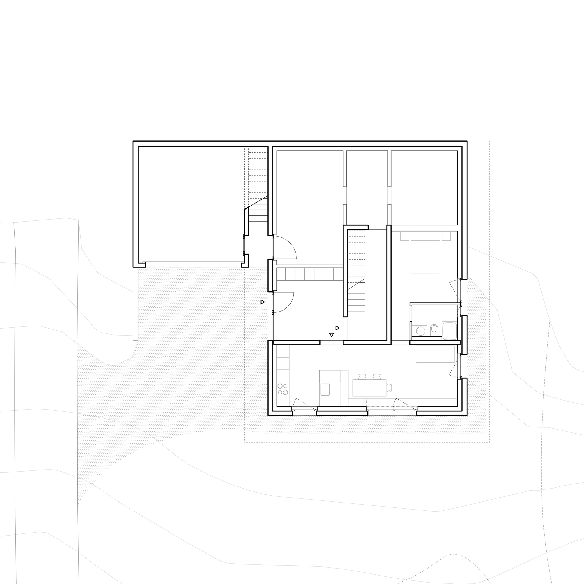 Floor plan drawing showing a rectangular volume with central staircase, bedroom, bathroom and open living space