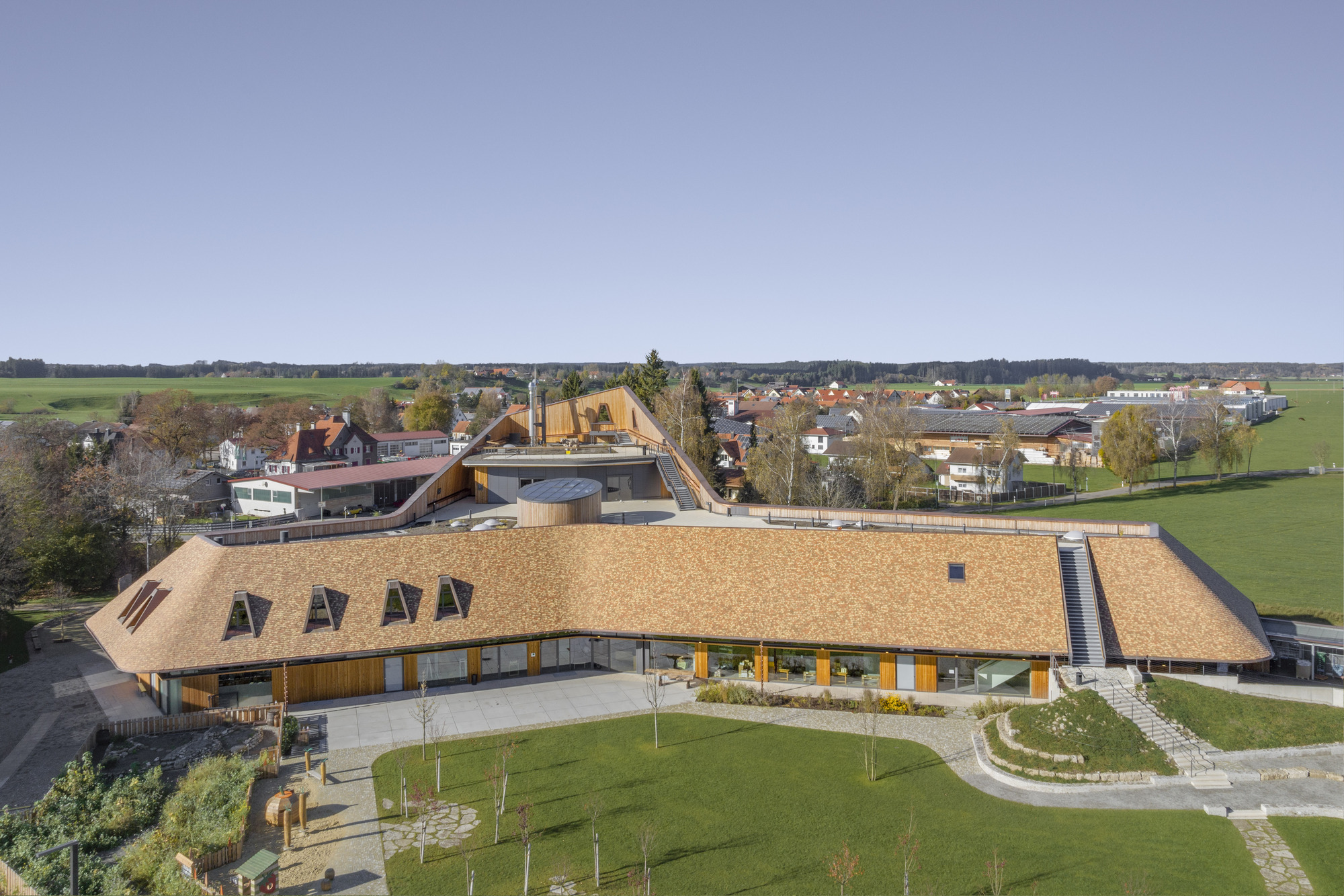 Aerial view of the thatched roofs with dormer windows set within a rural village landscape
