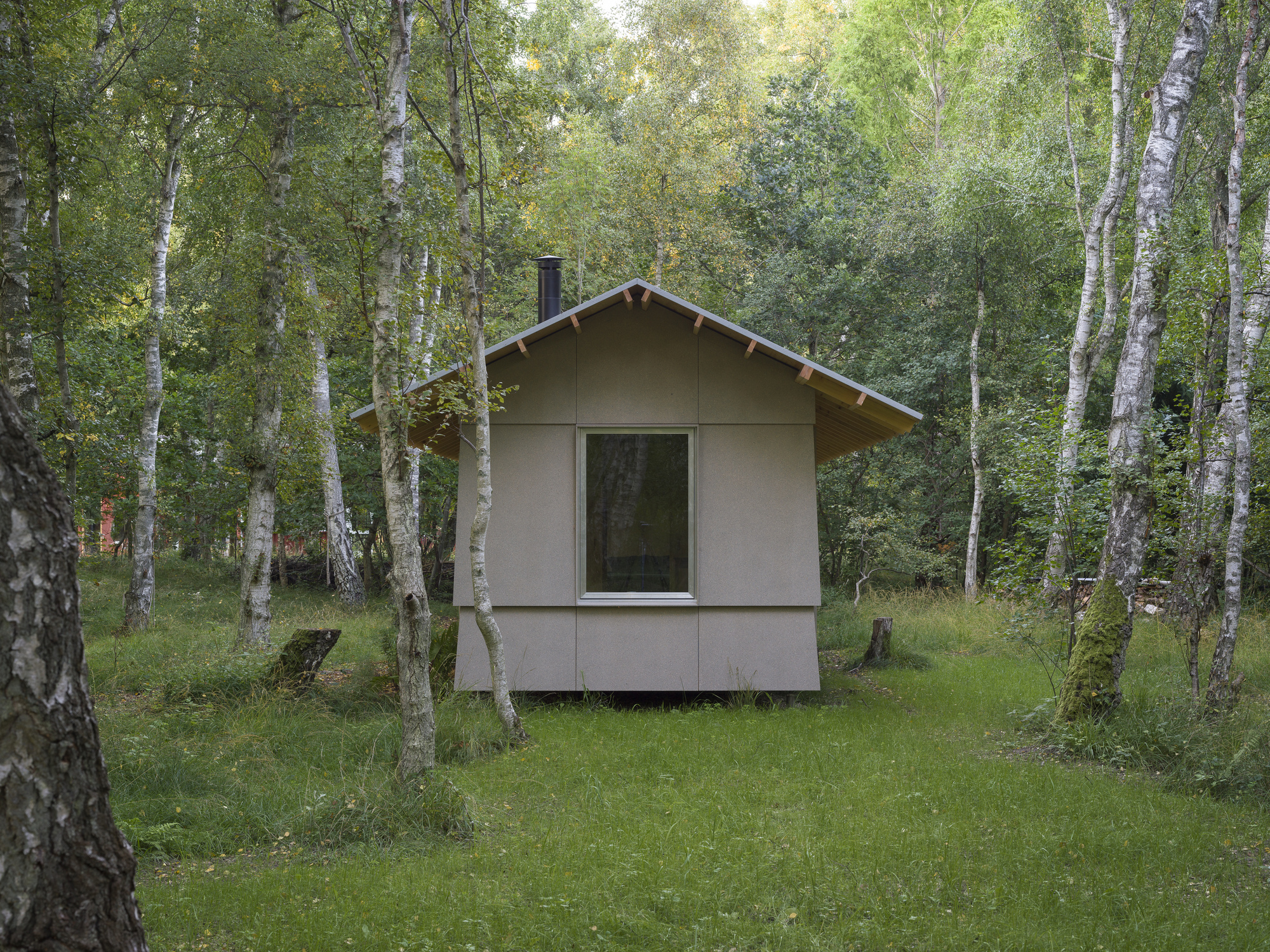Front elevation of the gabled annex volume with single window nestled between birch trees