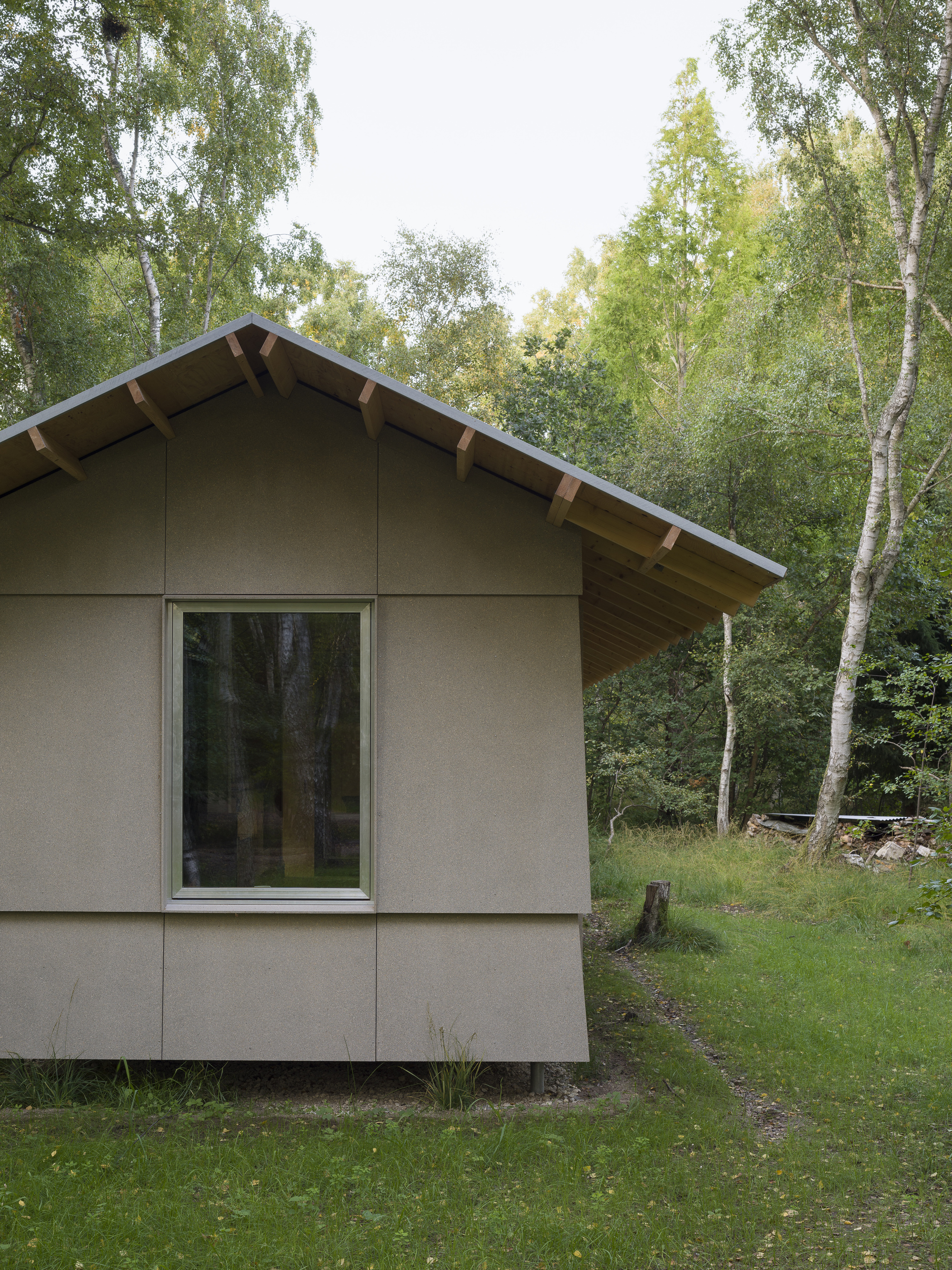 Corner detail of the gable end with exposed rafters and large glazed opening to the forest