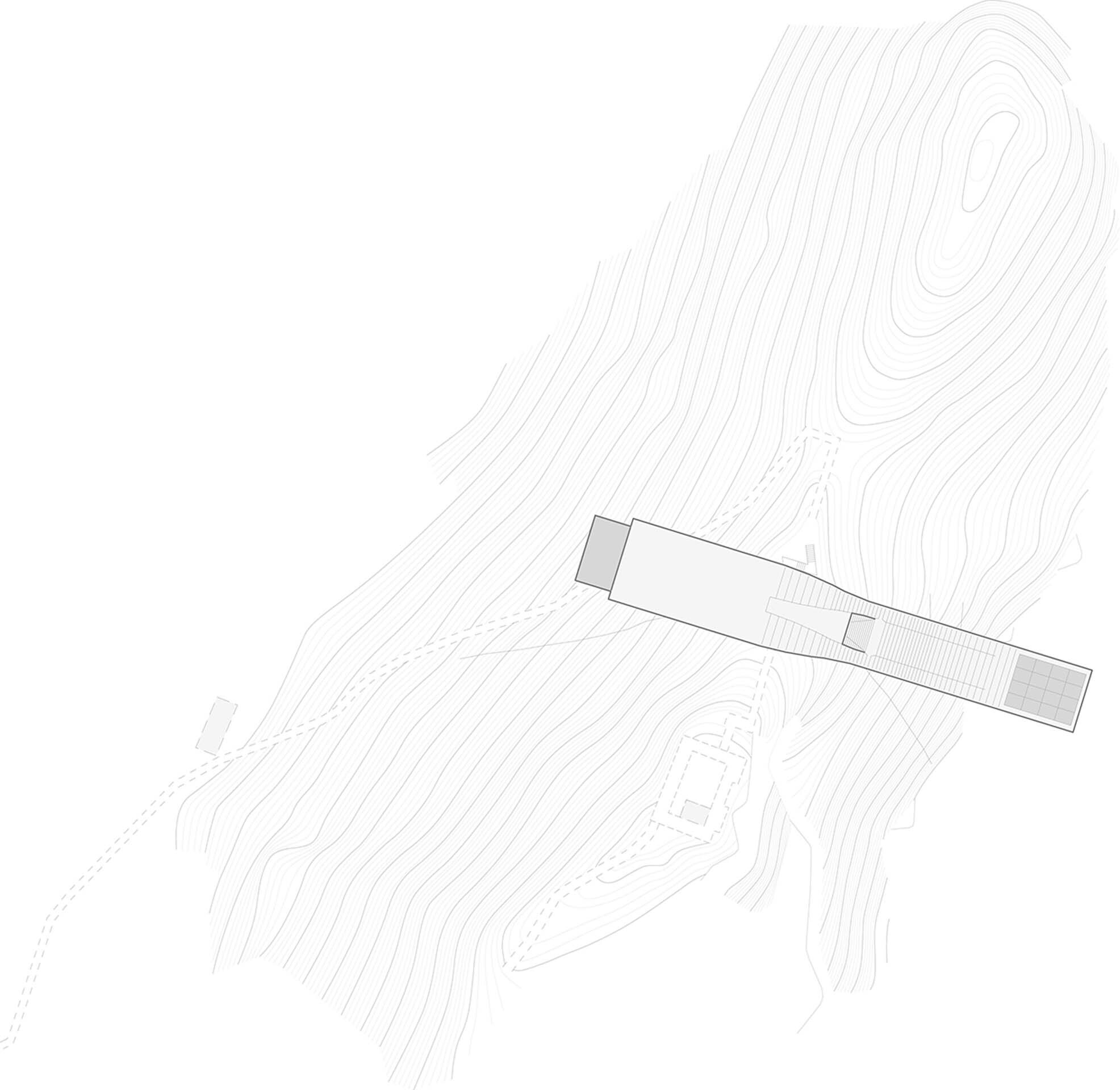 Site plan drawing showing a linear building positioned across contoured terrain with a rocky outcrop
