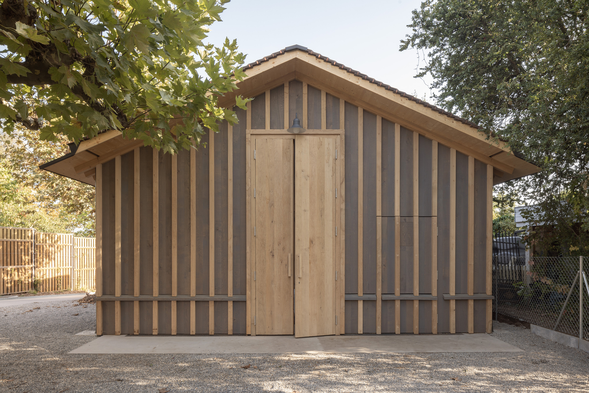 Rear gable end with vertical timber slat cladding and a tall timber door panel