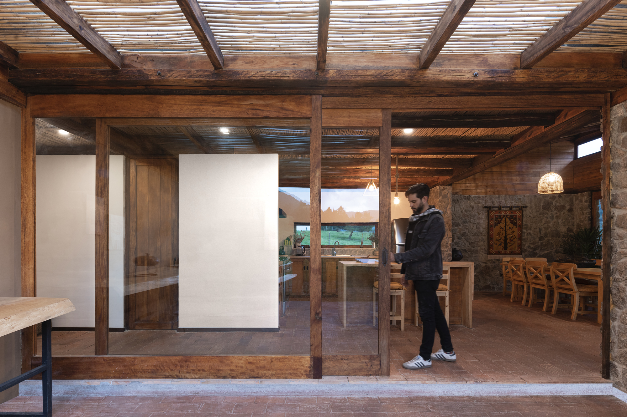 Timber frame threshold with sliding glass panels and a figure standing in the passage