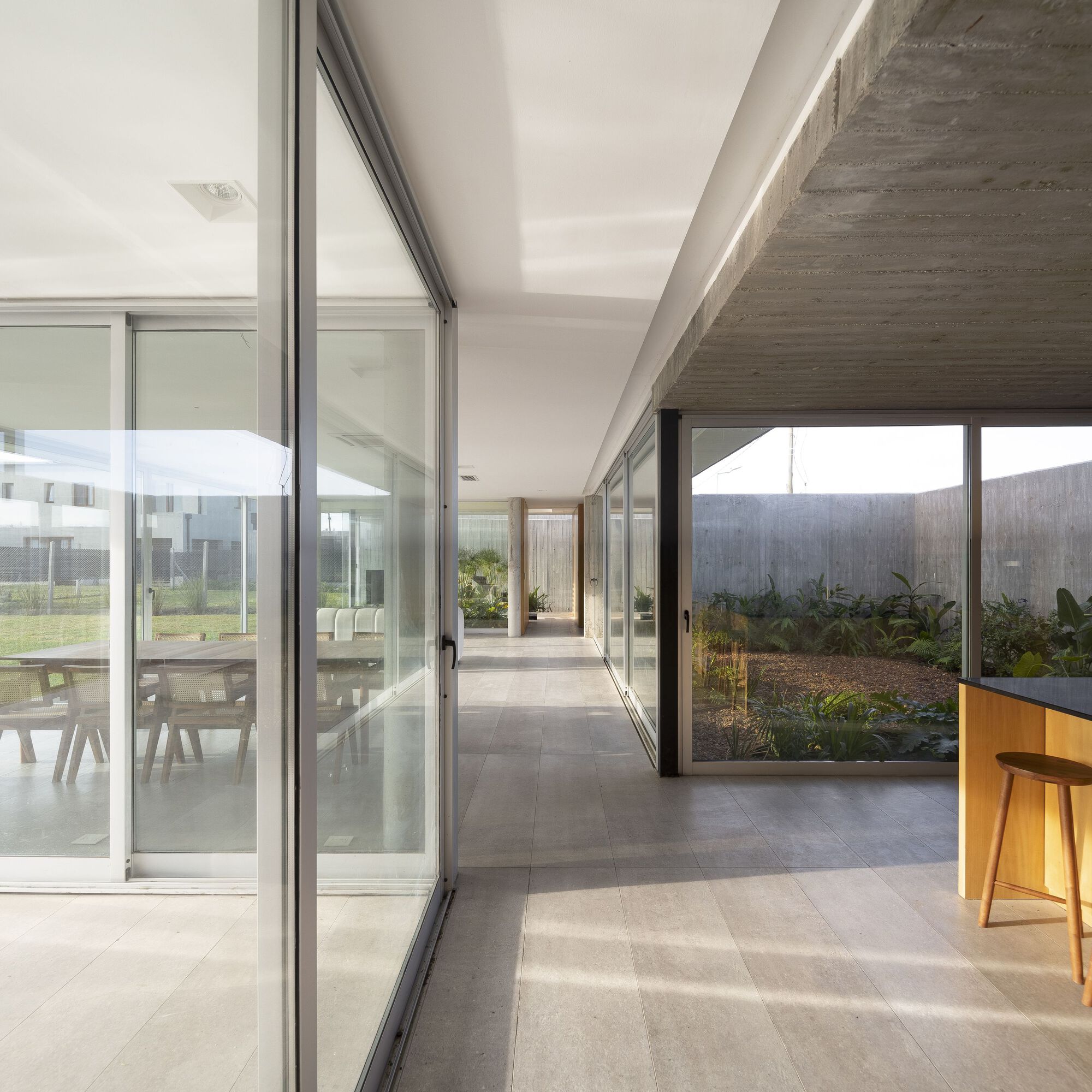 Glass corridor linking interior spaces with views to planted courtyards on both sides