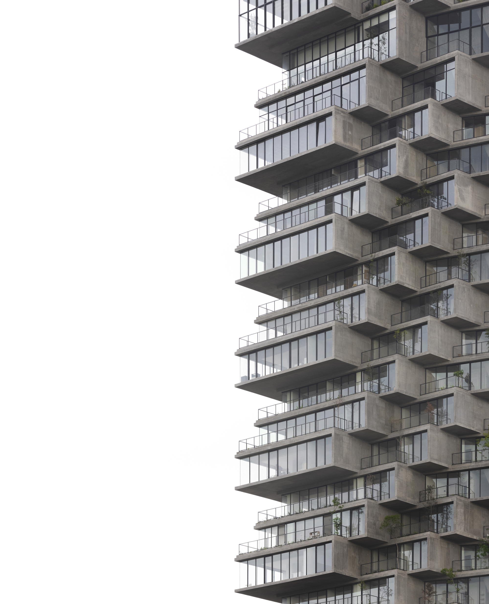 Alternating concrete slabs and glazed balconies in a stepped tower against pale sky