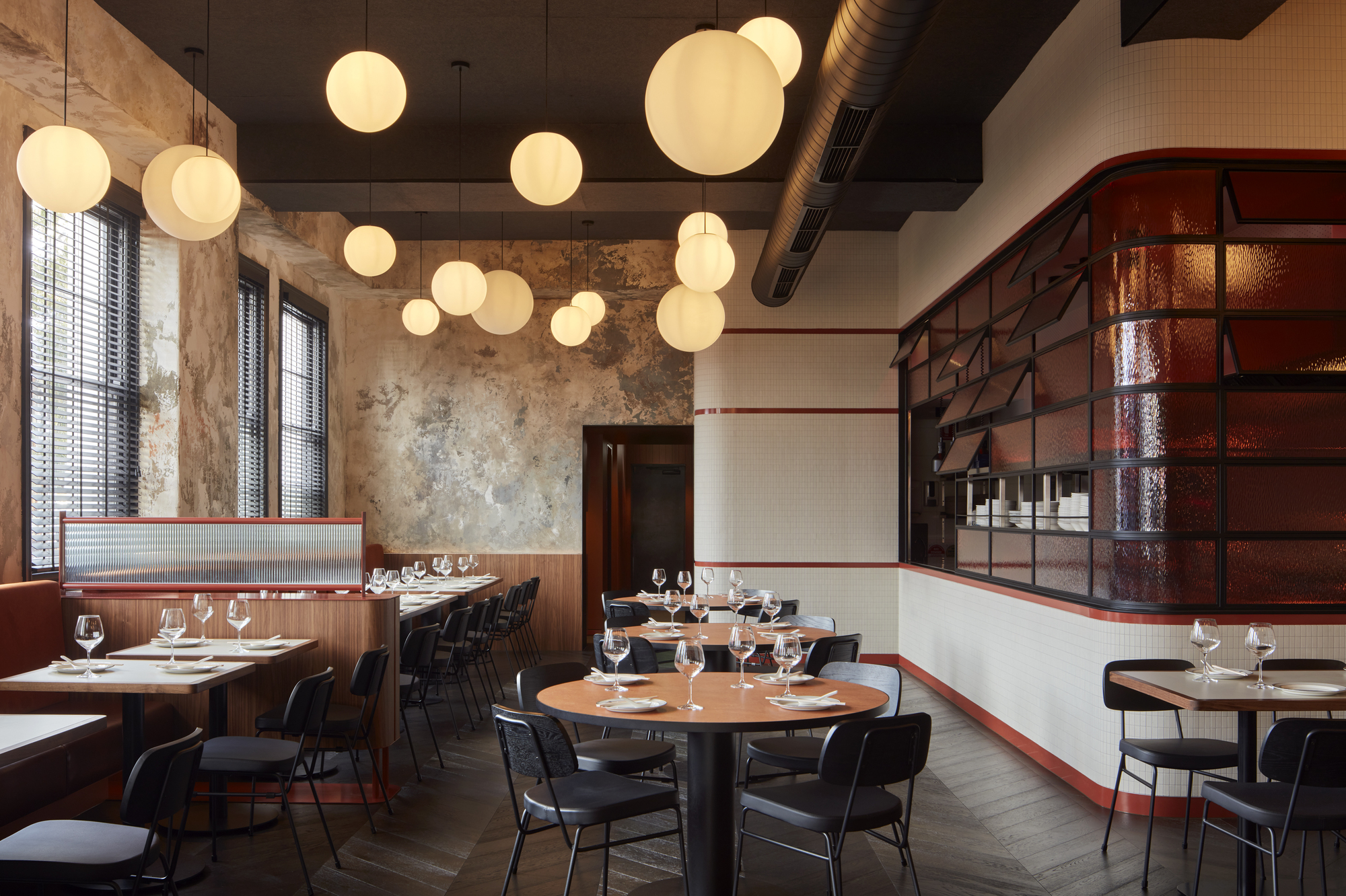 Dining room with sphere pendant lights, distressed plaster walls, and maroon tiled wine display niche