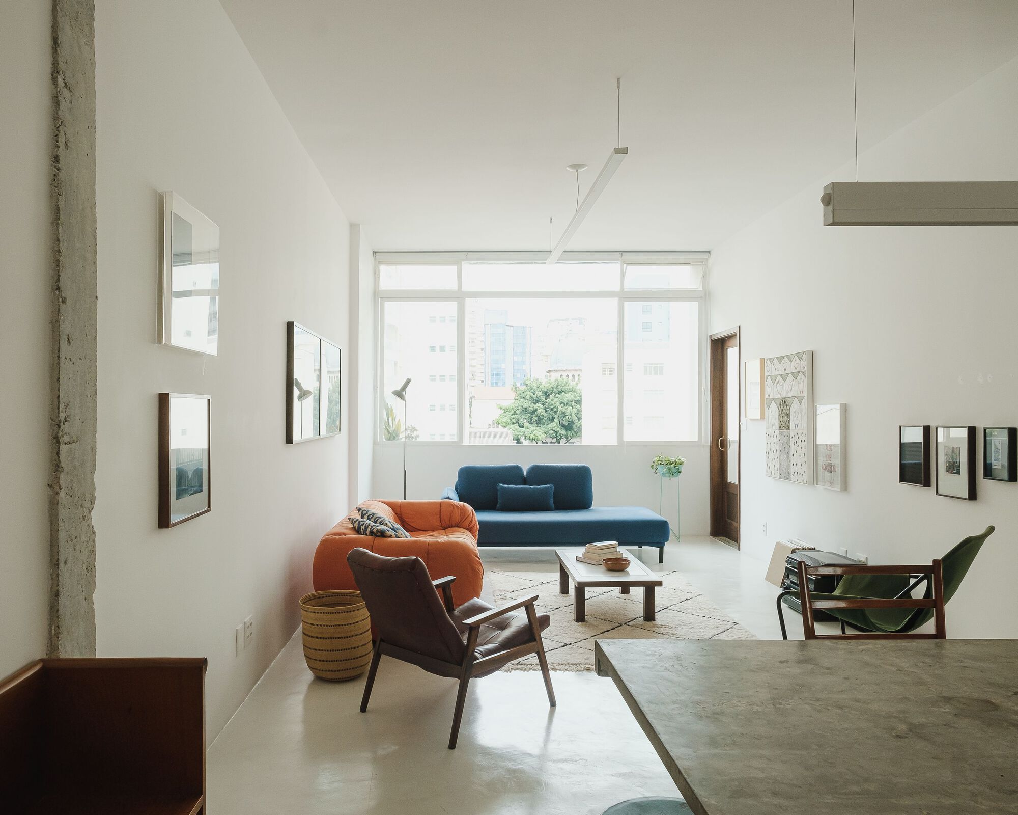 Living room with mid-century seating facing a large gridded window with diffused daylight