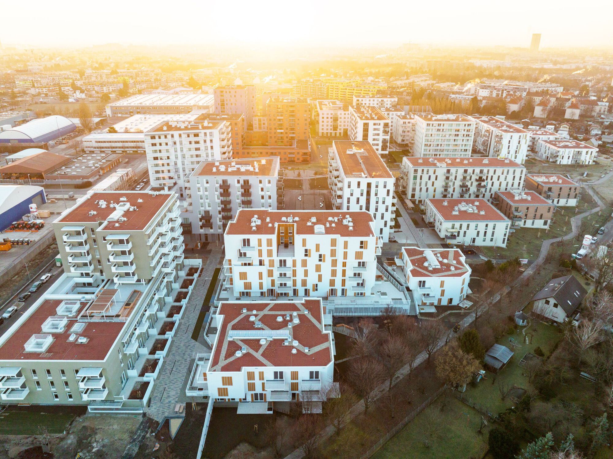 Aerial view of the white residential blocks with terracotta roofs in golden sunset haze