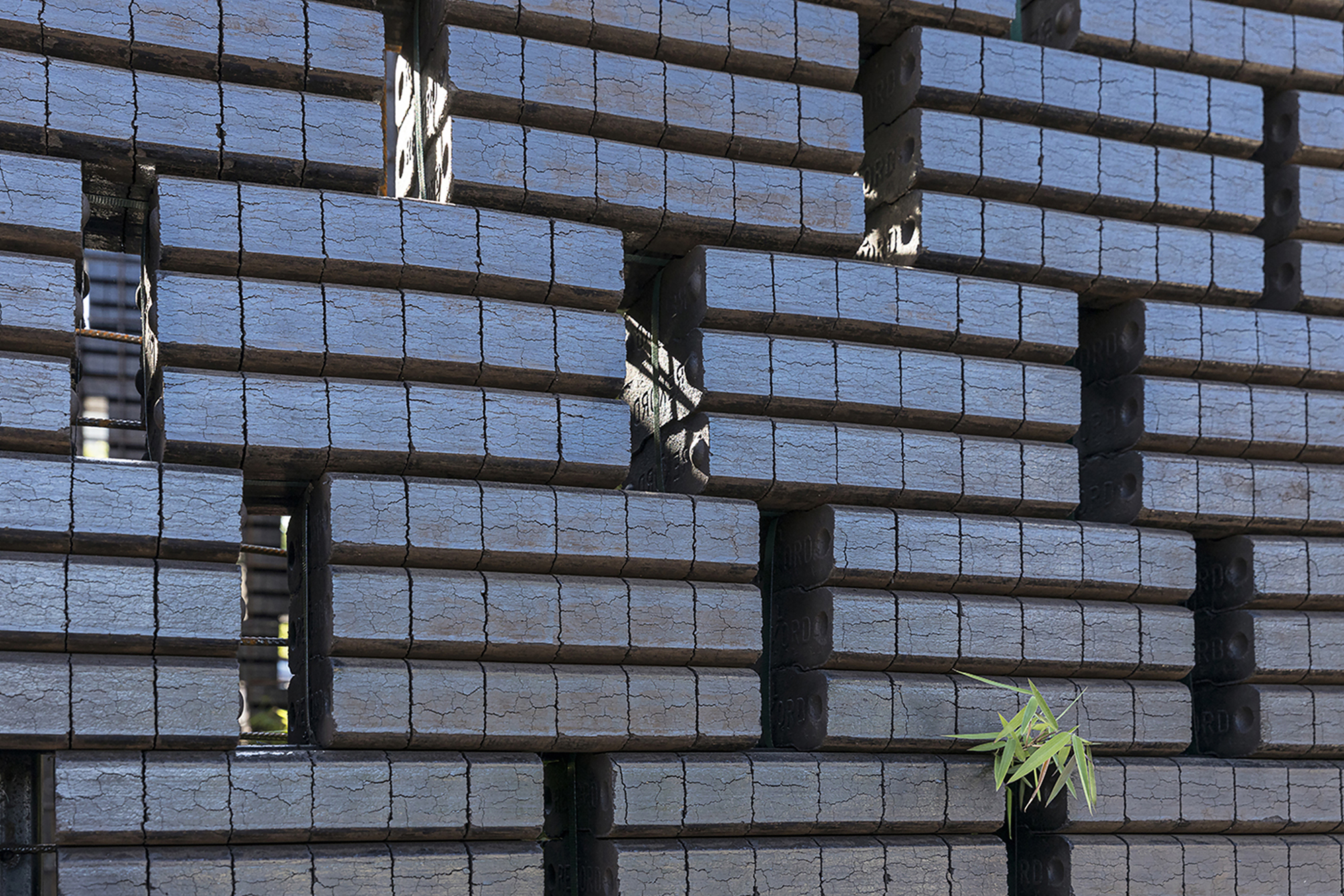 Close-up of the woven timber slat facade with a small planted opening