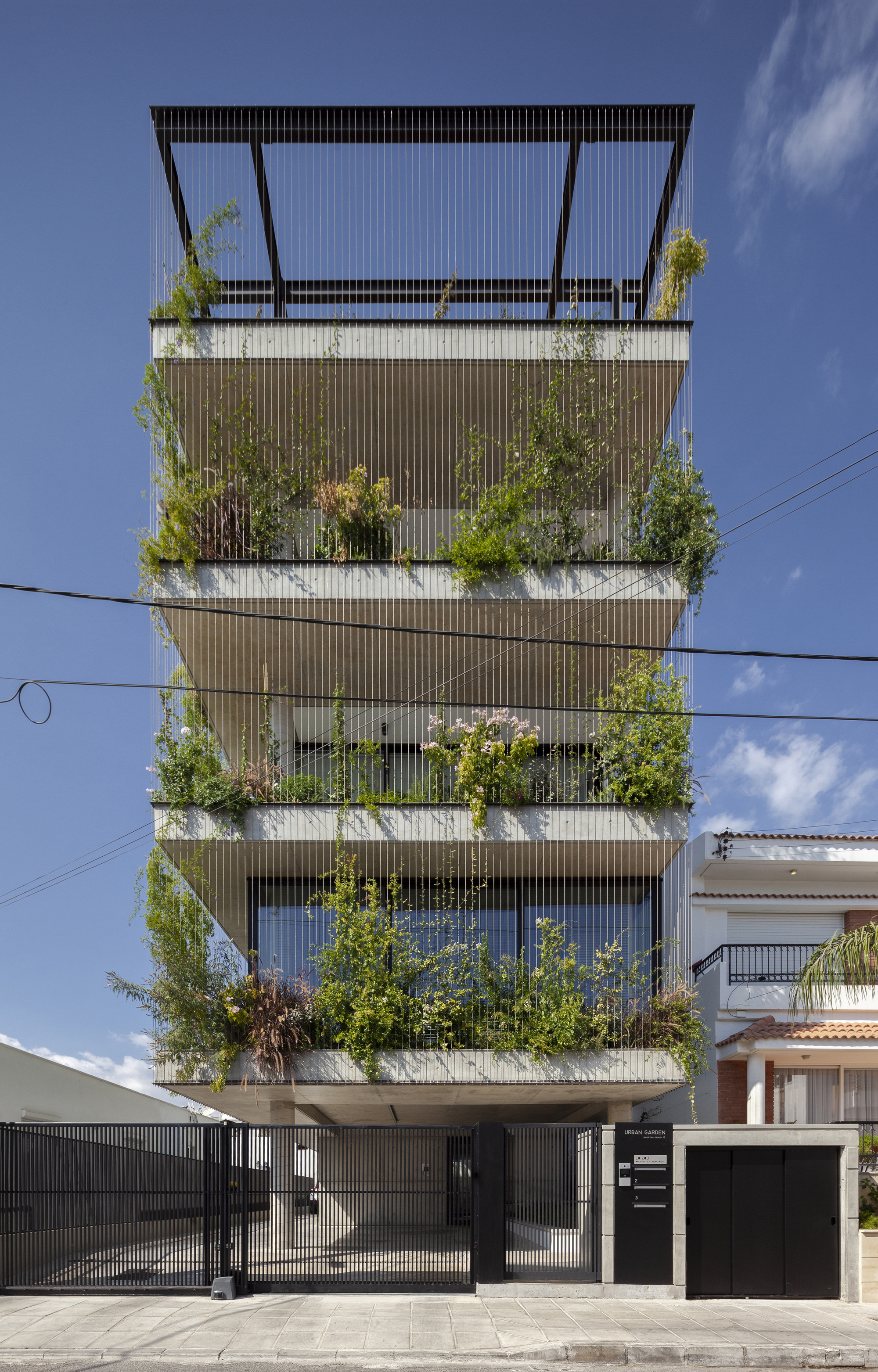 Facade detail of the vertical louvered screens with greenery spilling from each balcony level