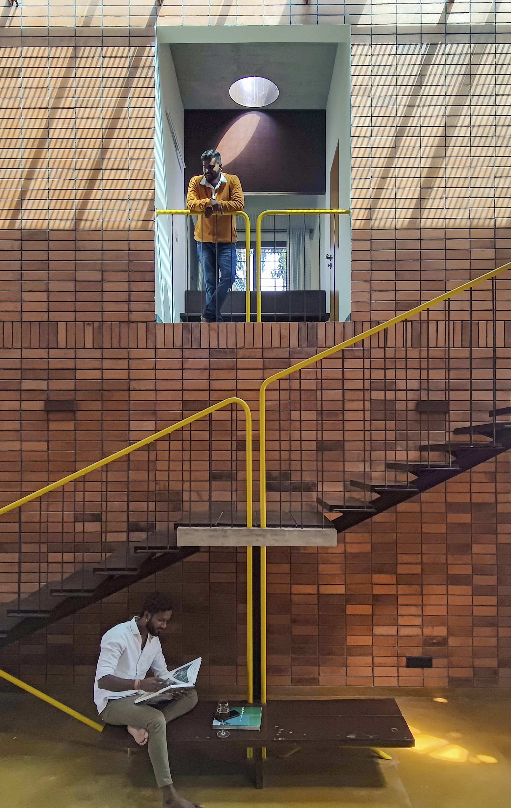 Stairwell crossing the double-height space with two people using the different levels