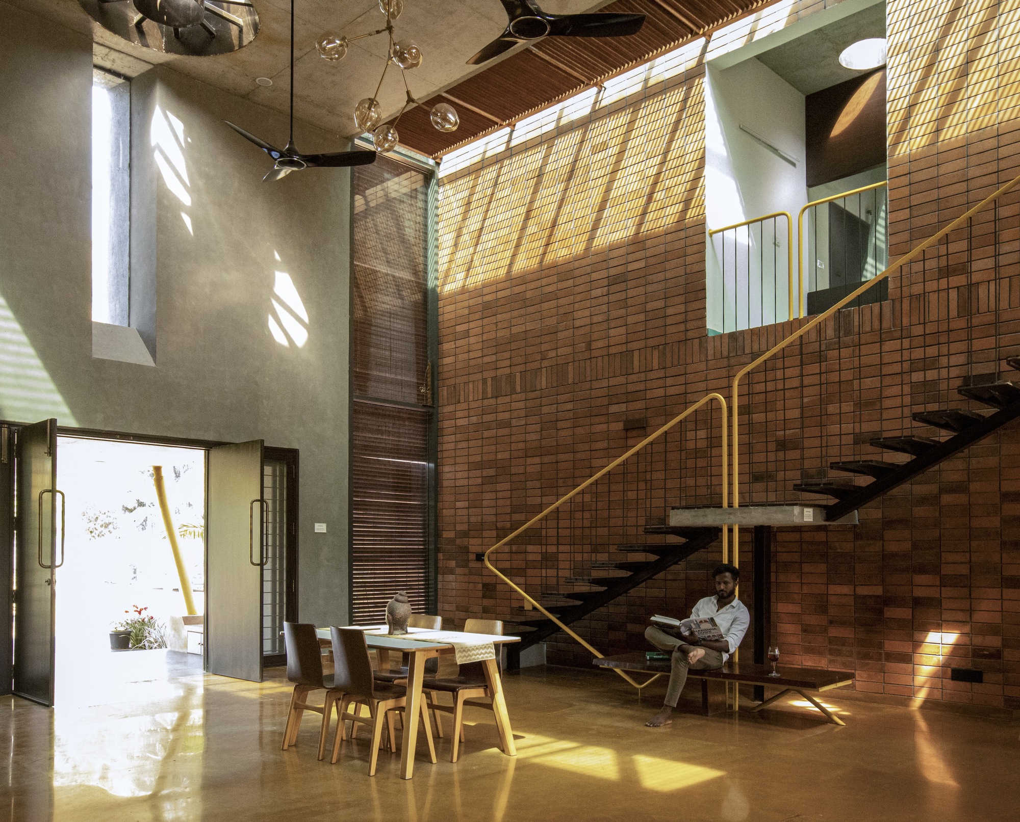 Dining area below the staircase with natural light streaming through clerestory windows