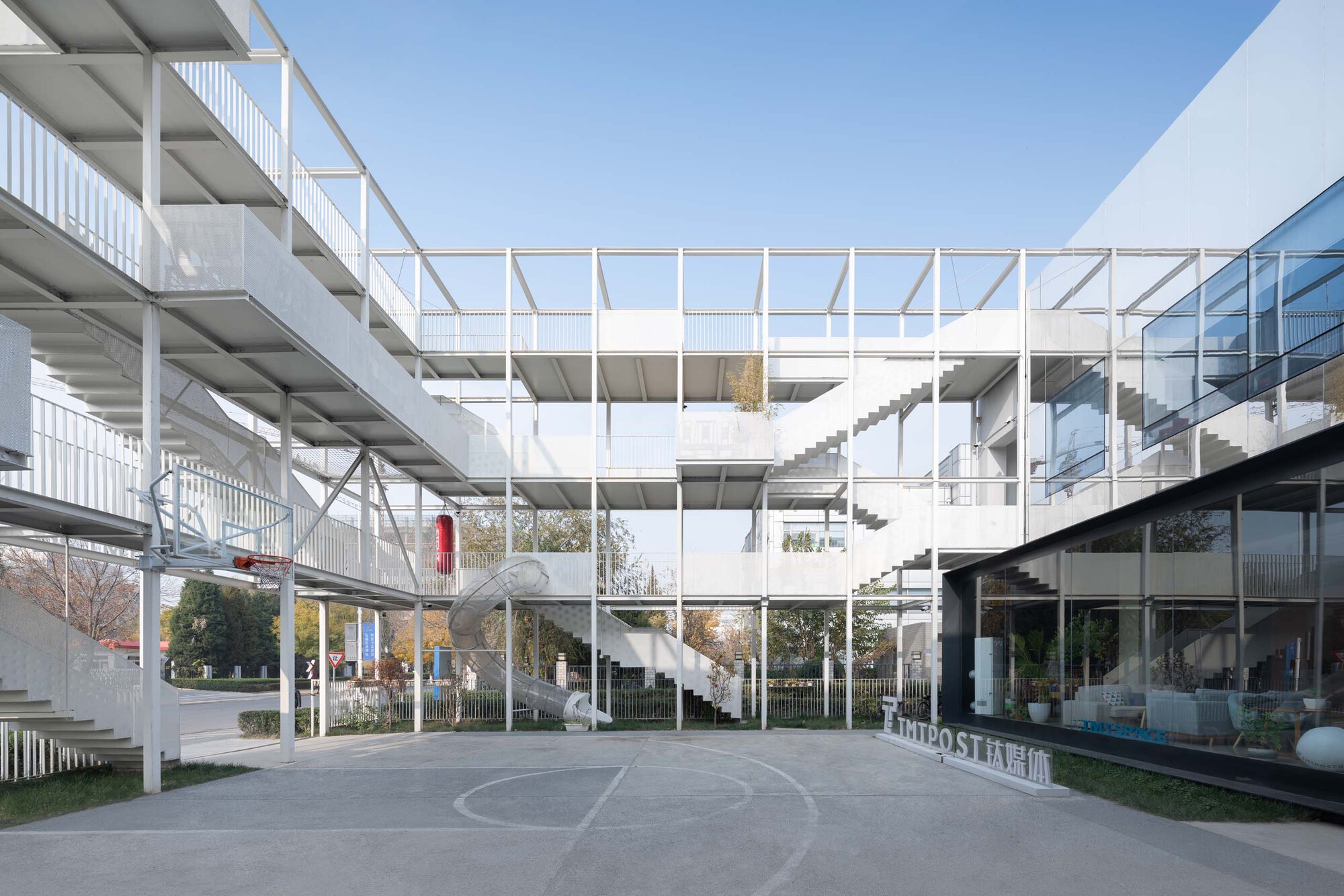 White steel frame structure with exposed floors and staircases surrounding a central courtyard
