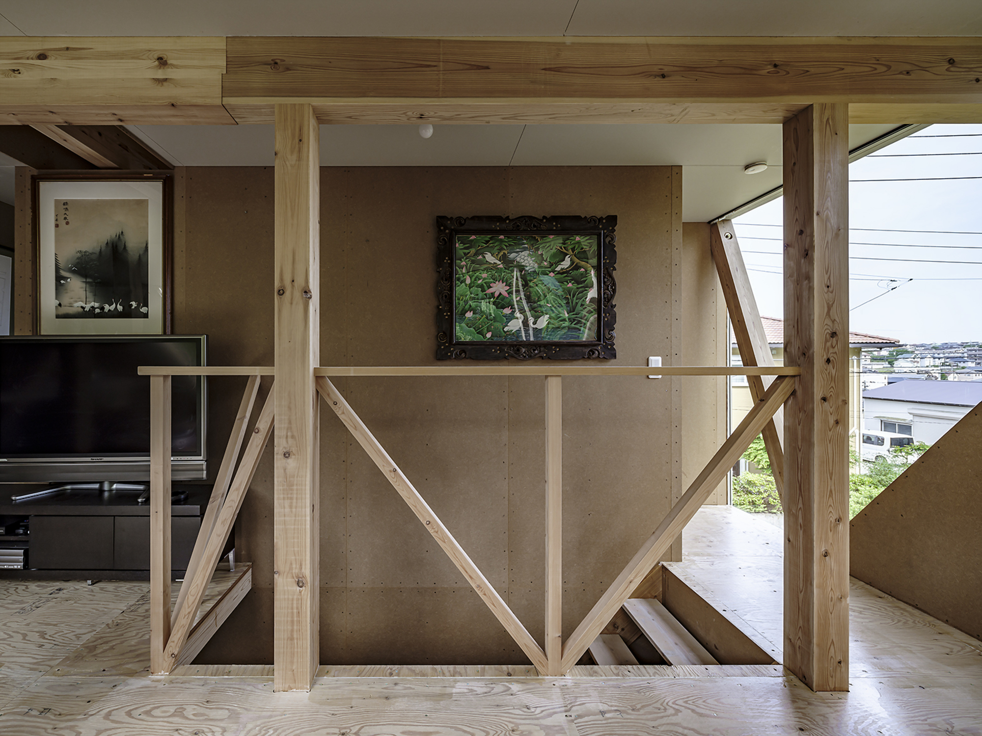 Diagonal timber balustrade with exposed posts framing a concrete wall and view to the harbor beyond