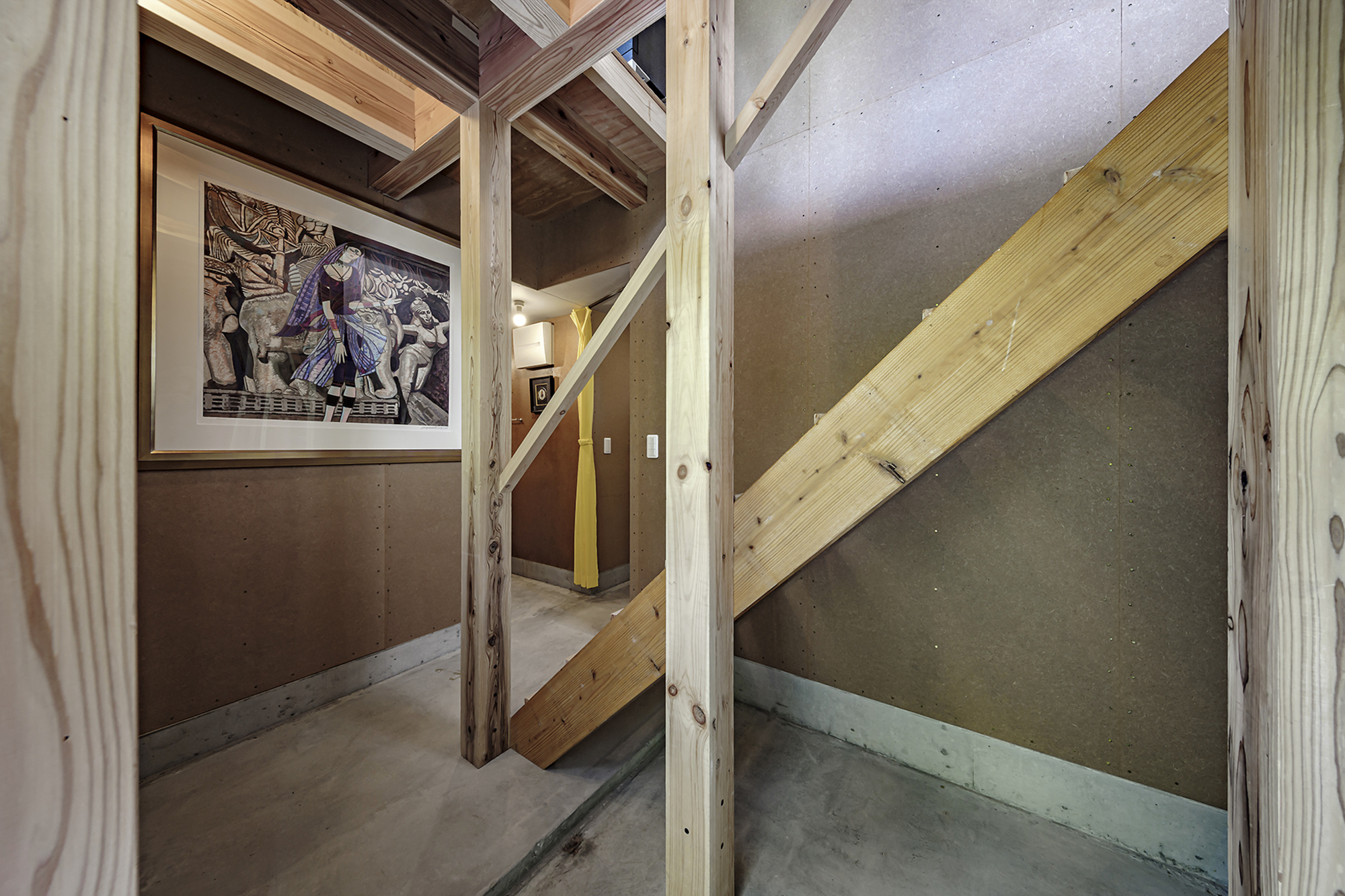 Landing view showing diagonal timber stringer against concrete walls with exposed structural framing above