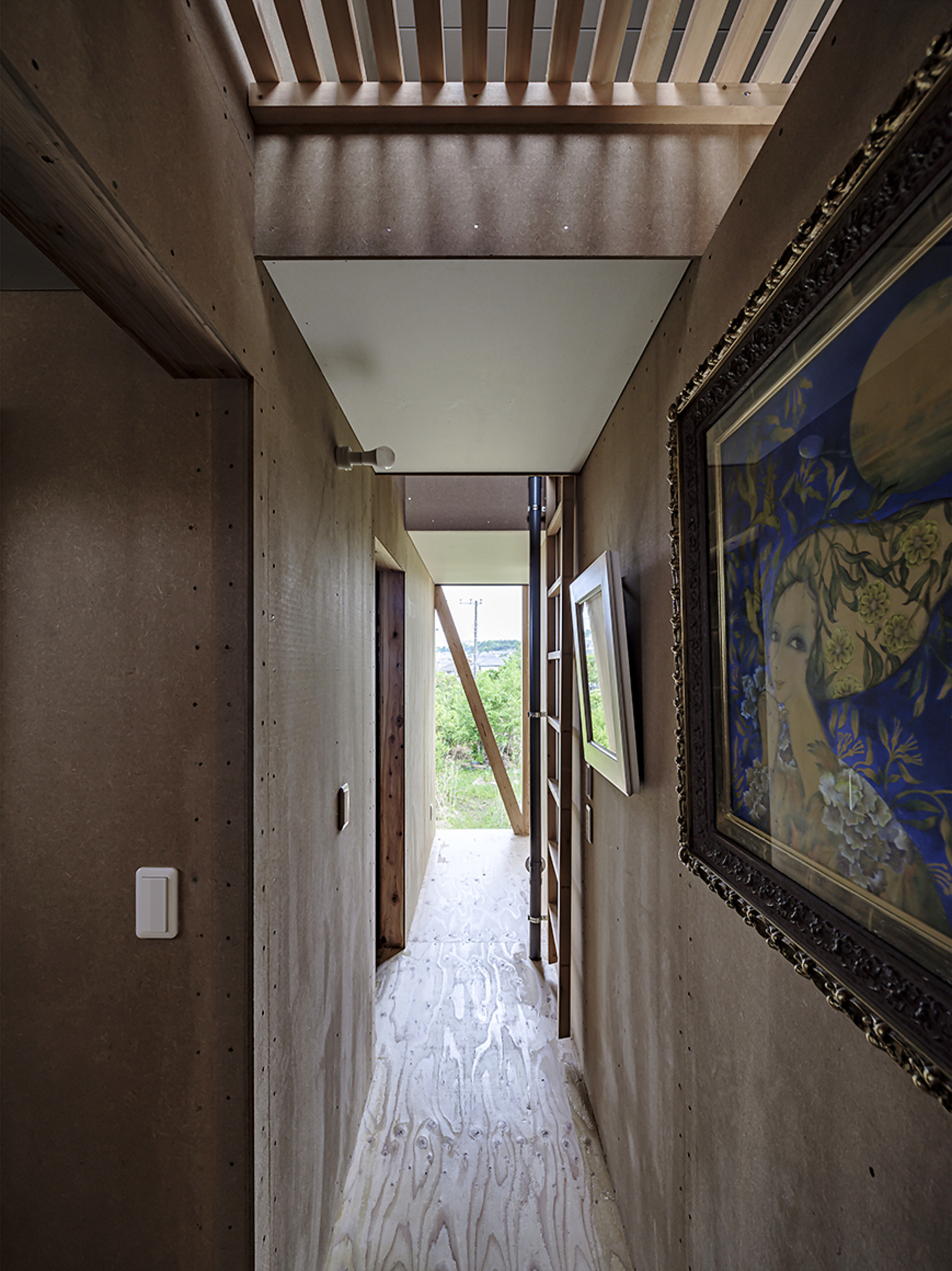 Concrete corridor with exposed ceiling joists and diagonal timber brace visible through open doorway