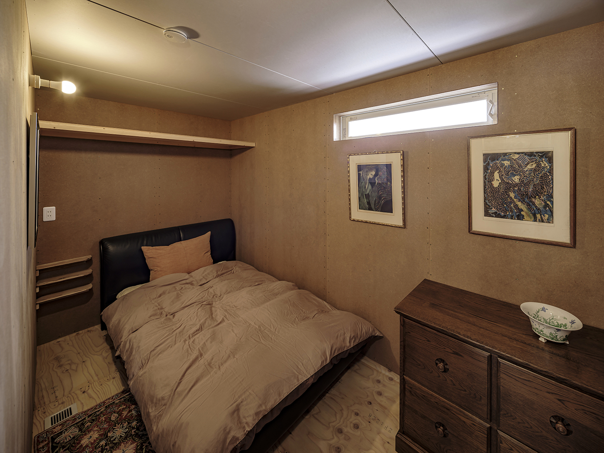 Bedroom with horizontal plywood wall panels and high ribbon window under a white ceiling