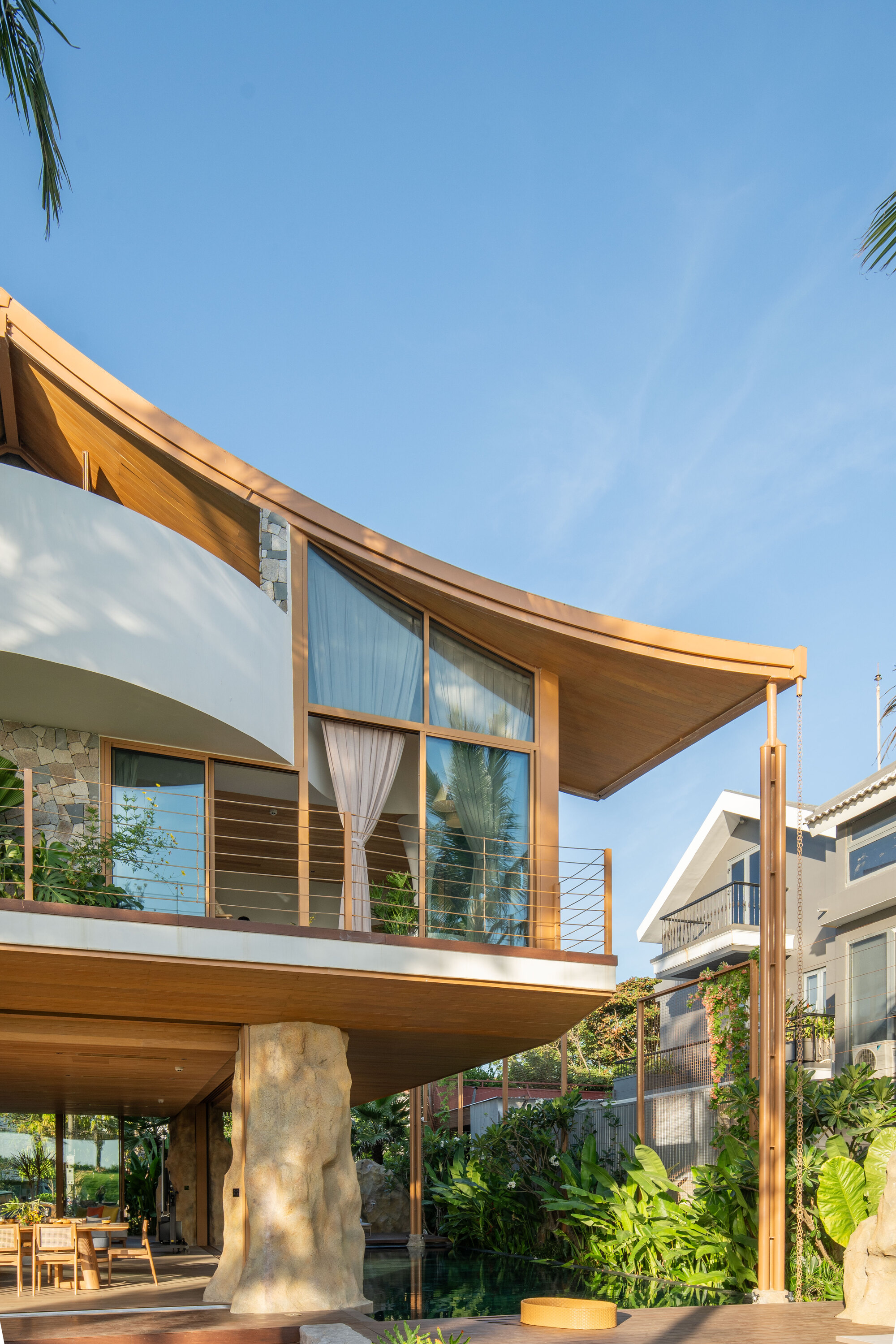 Cantilevered upper floor supported by a sculptural white column beneath the timber overhang