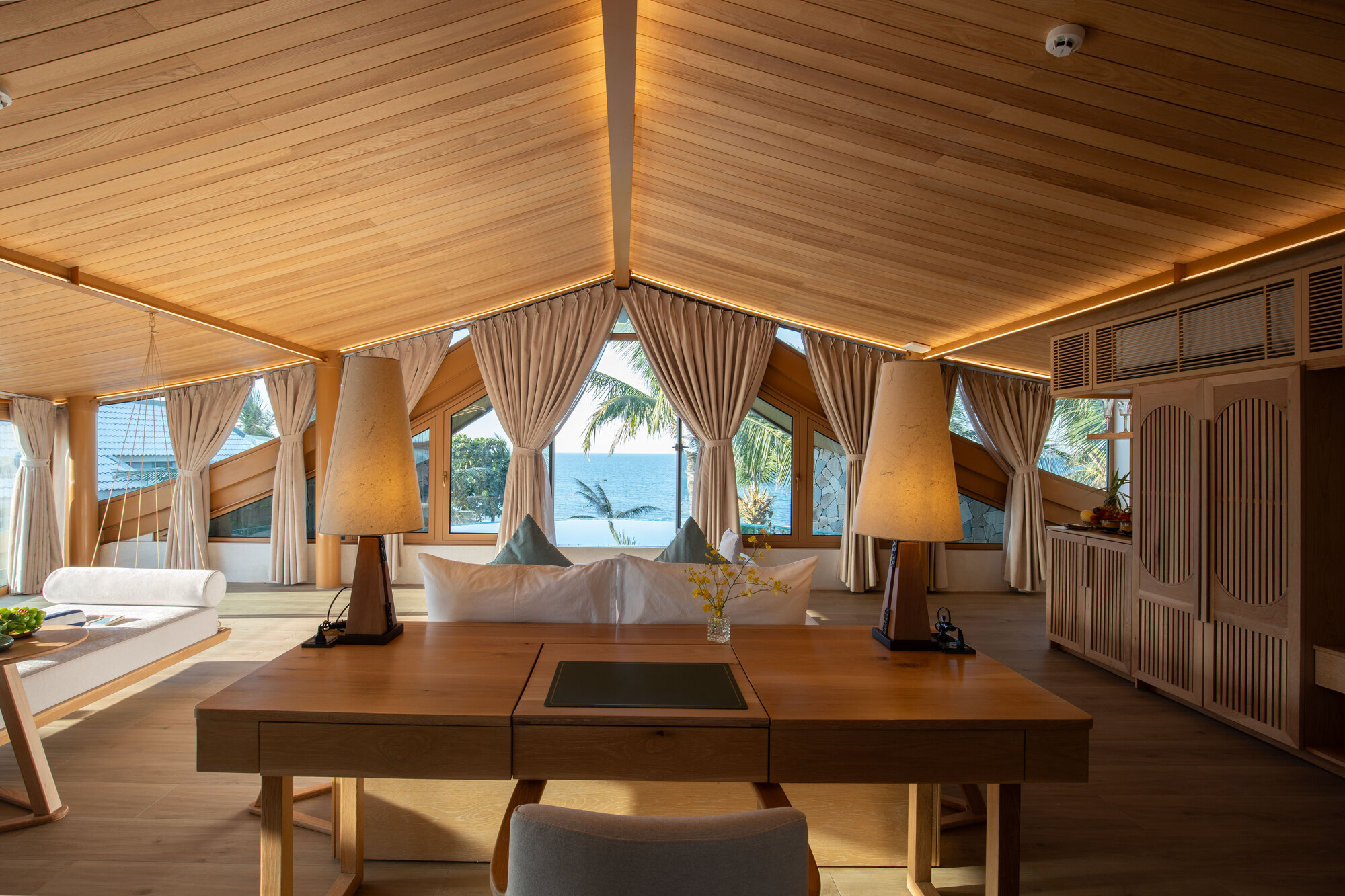 Interior living space with vaulted timber ceiling and clerestory windows framing palm views