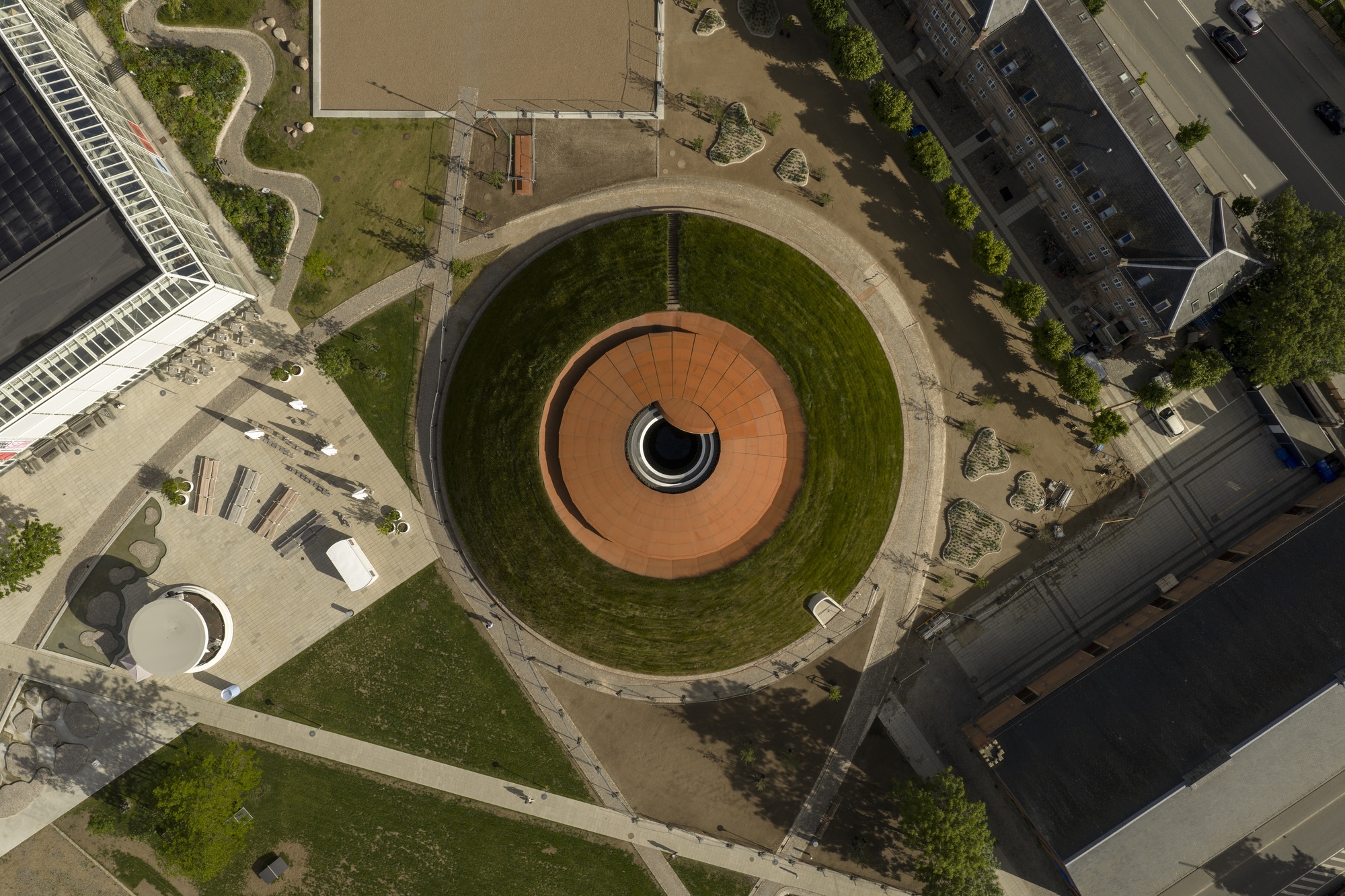 Aerial view of the circular sunken courtyard with concentric grass terraces and orange tile center