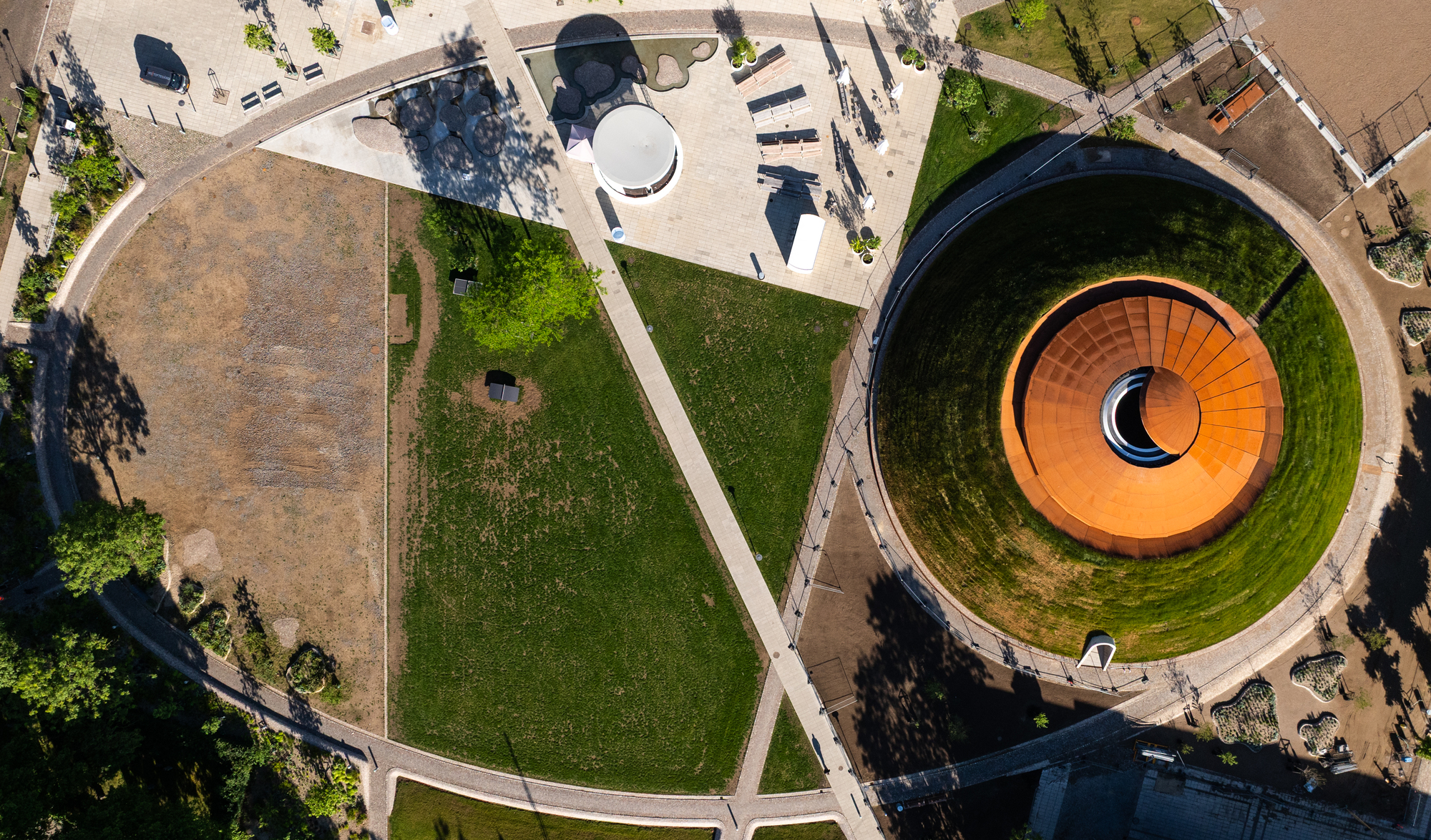 Drone view showing the circular courtyard and diagonal pathways connecting lawn areas and adjacent buildings