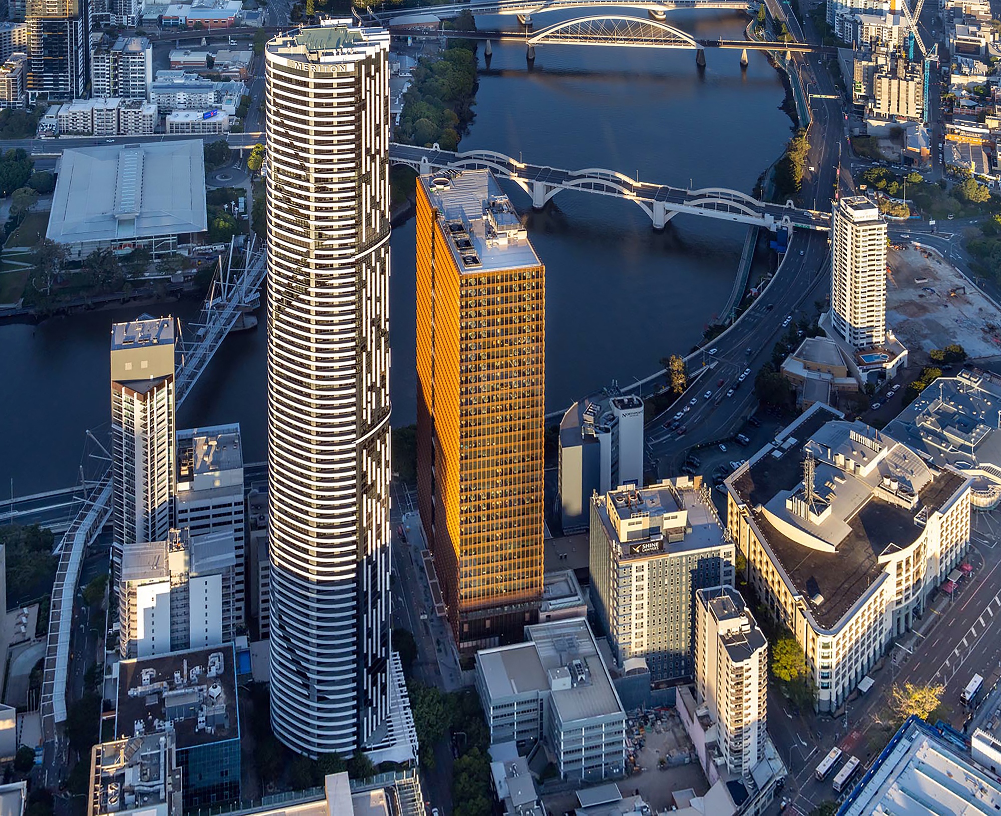 Drone view of the cylindrical and rectangular towers rising above the river and surrounding urban blocks
