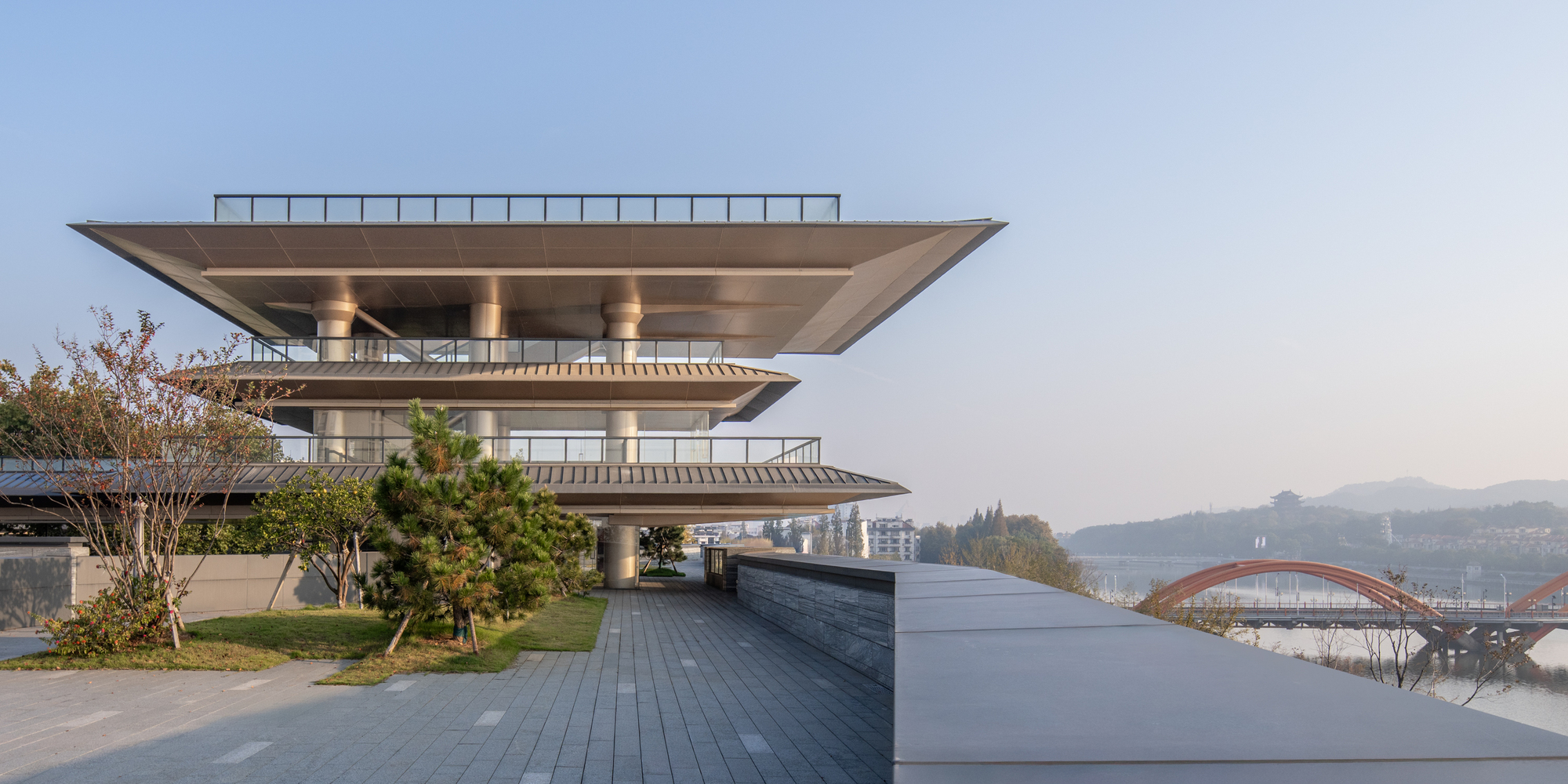 Cantilevered roof terraces overlooking the reflecting pool and distant mountains in clear daylight