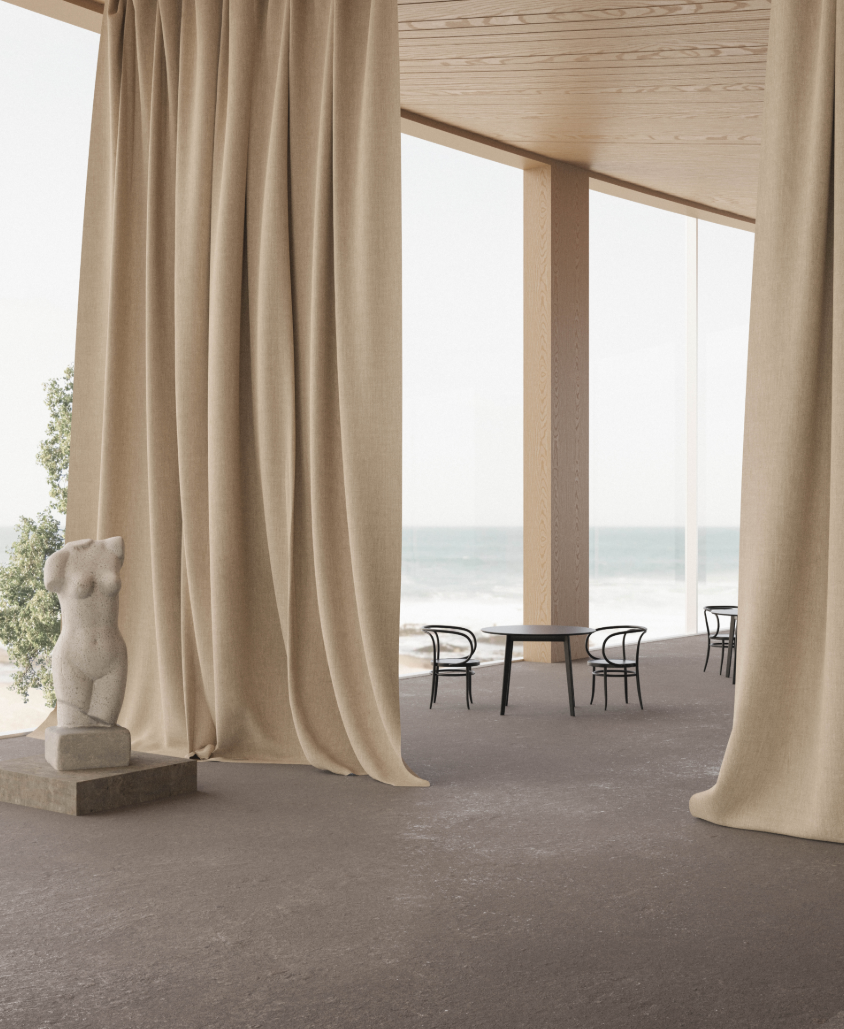 Interior view through floor-to-ceiling linen curtains toward a terrace with table and chairs facing the water