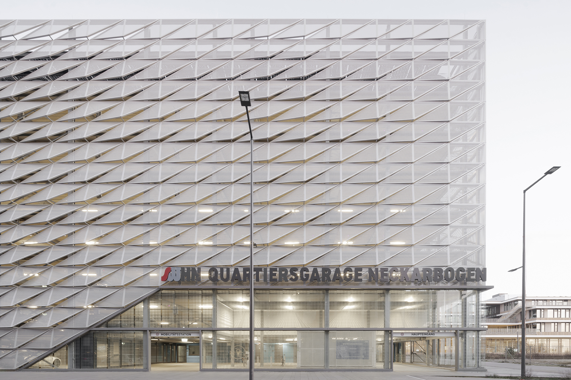 Front elevation showing the perforated metal screen above a fully glazed ground floor entry