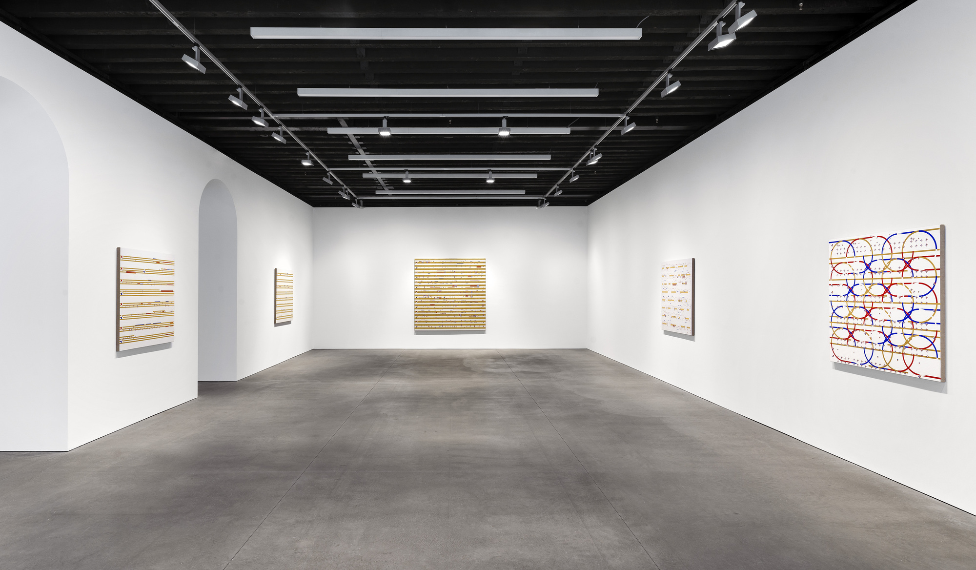 Gallery room with white walls, black exposed joist ceiling and polished concrete floor