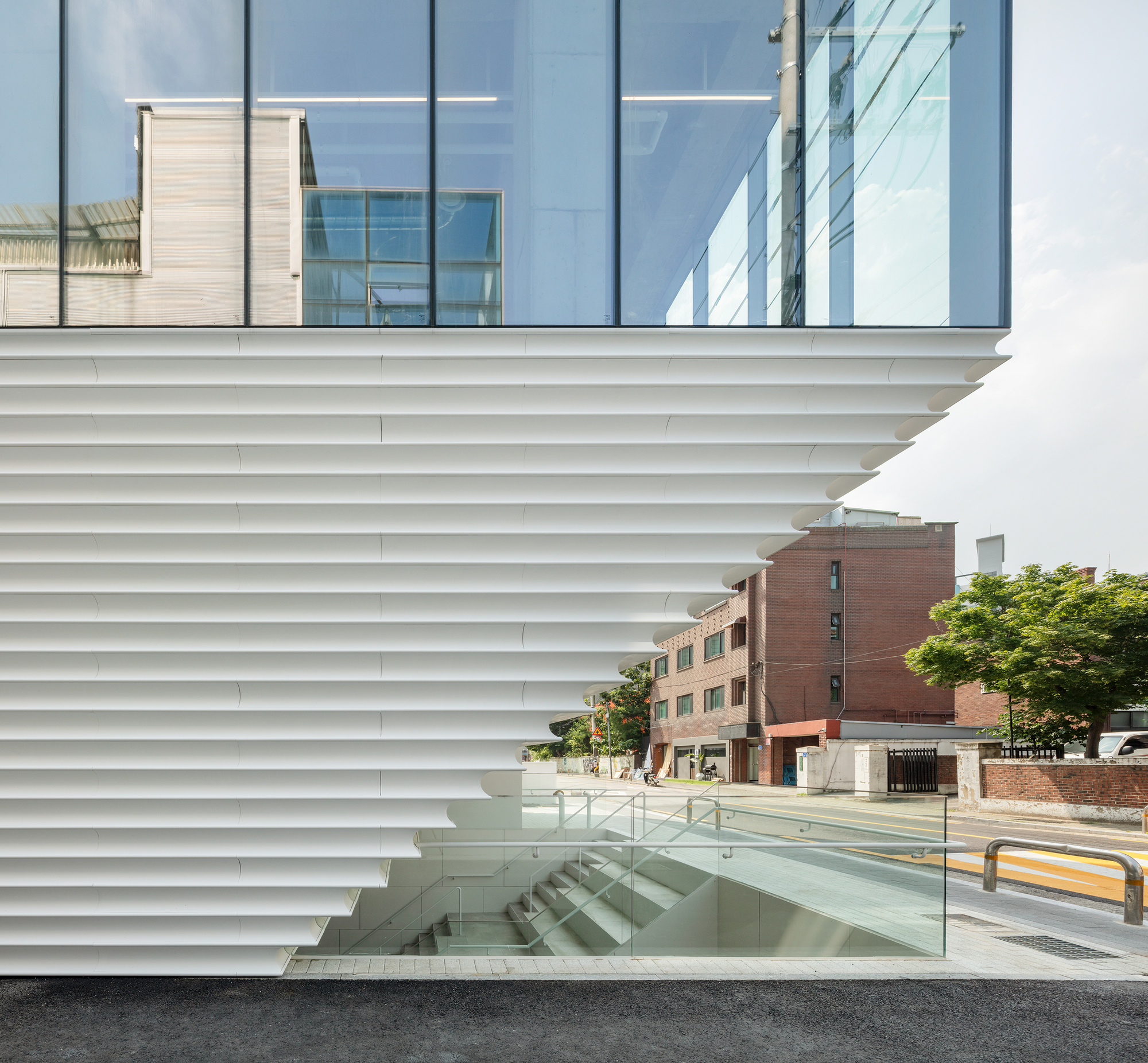 Corner detail of the horizontal louver cladding above a glazed stair entry at street level
