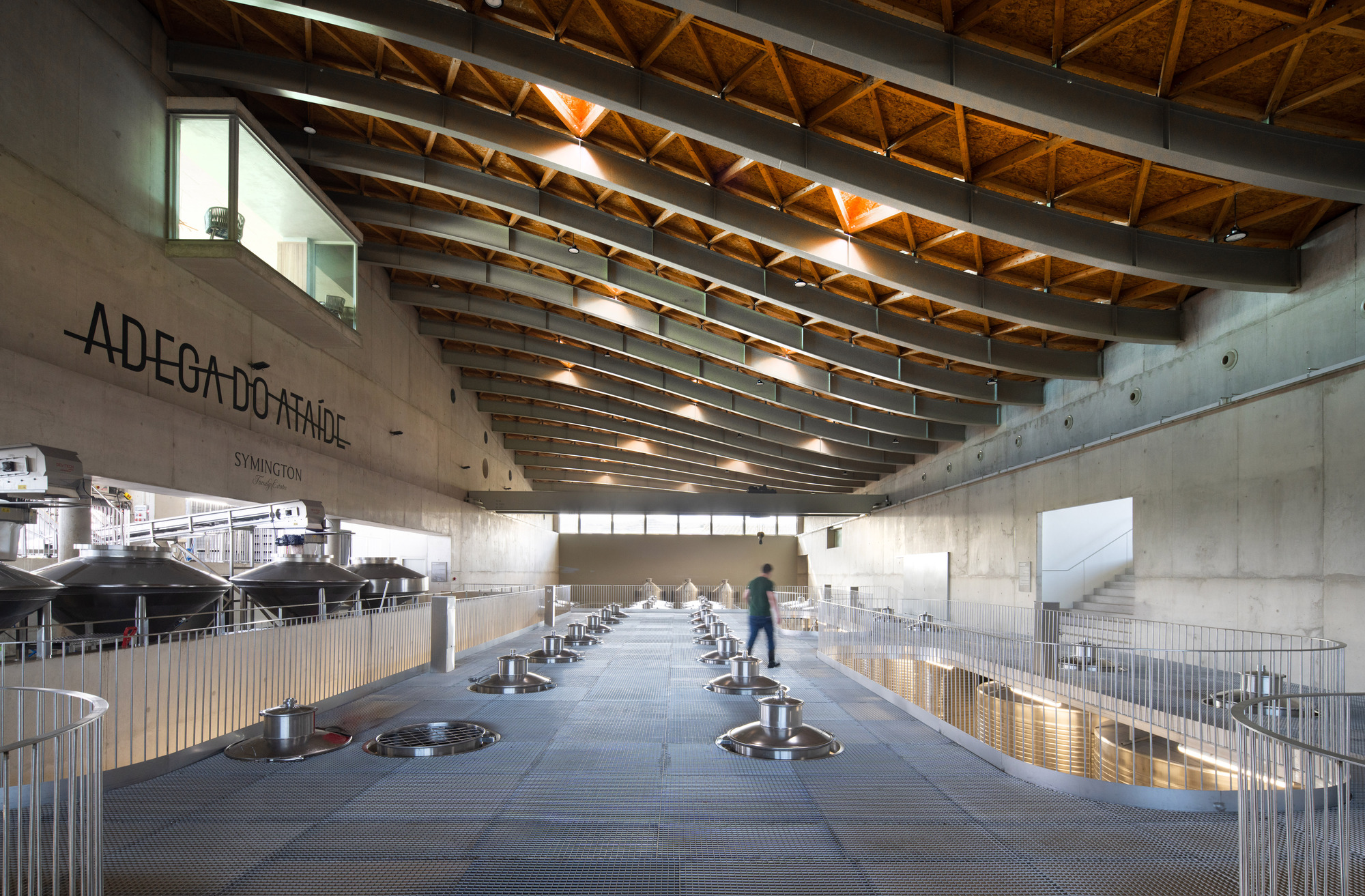 Interior processing floor with fermentation tanks, concrete walls and illuminated timber truss ceiling