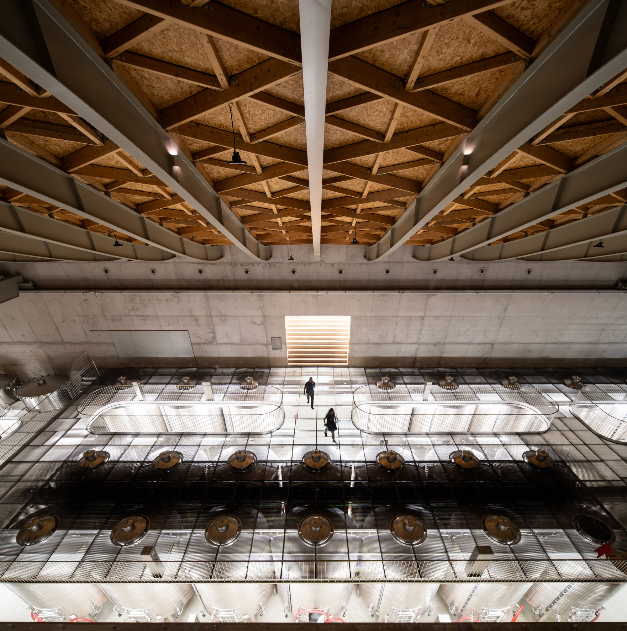 Interior view of the production floor with exposed concrete beams and coffered cork ceiling panels