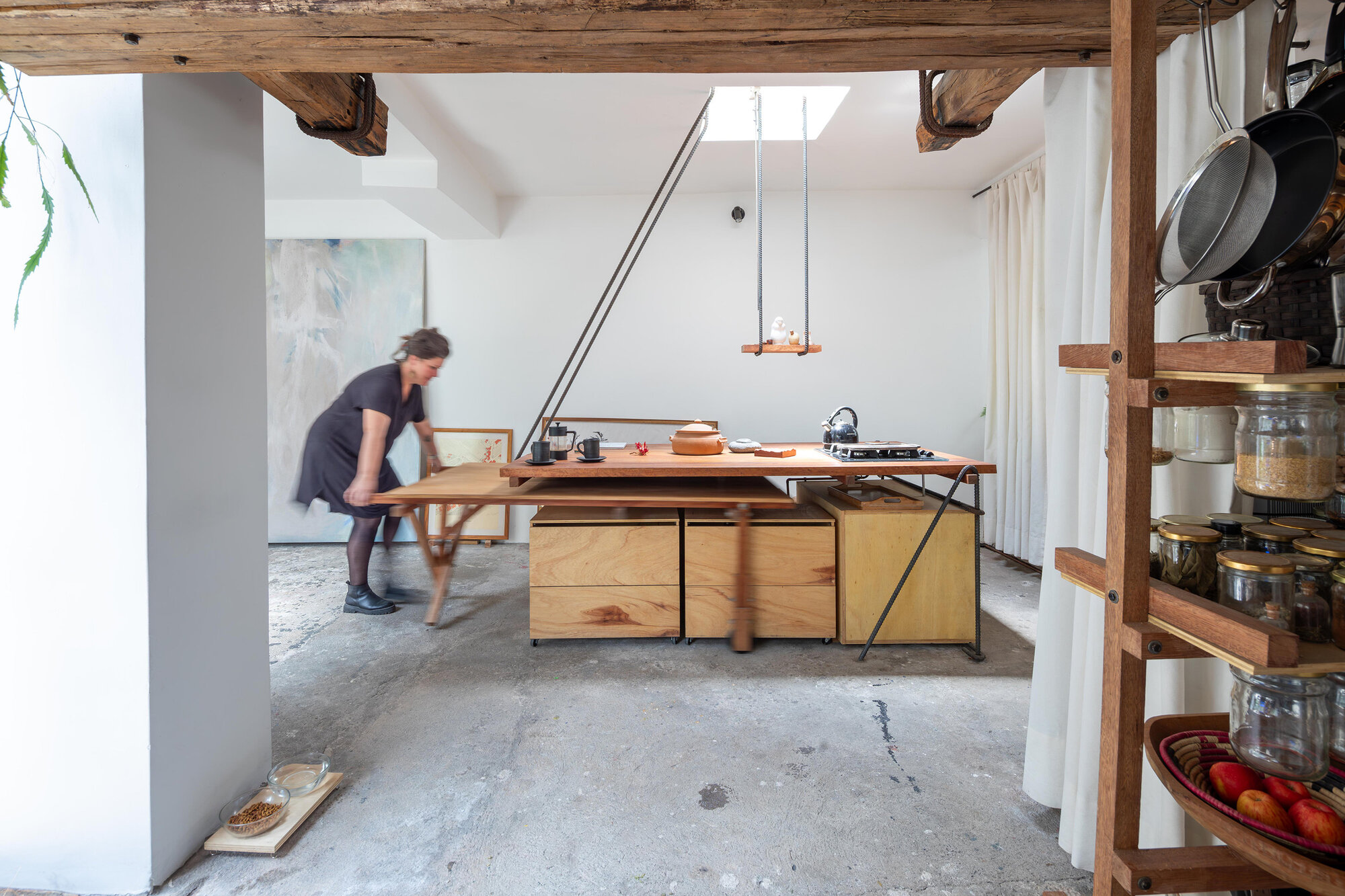 Open kitchen with custom timber countertop island and exposed beam ceiling lit by skylight above