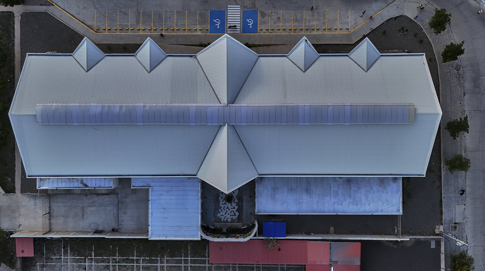Aerial view of the metal roof showing repeating pyramidal peaks and translucent canopy over entrance plaza