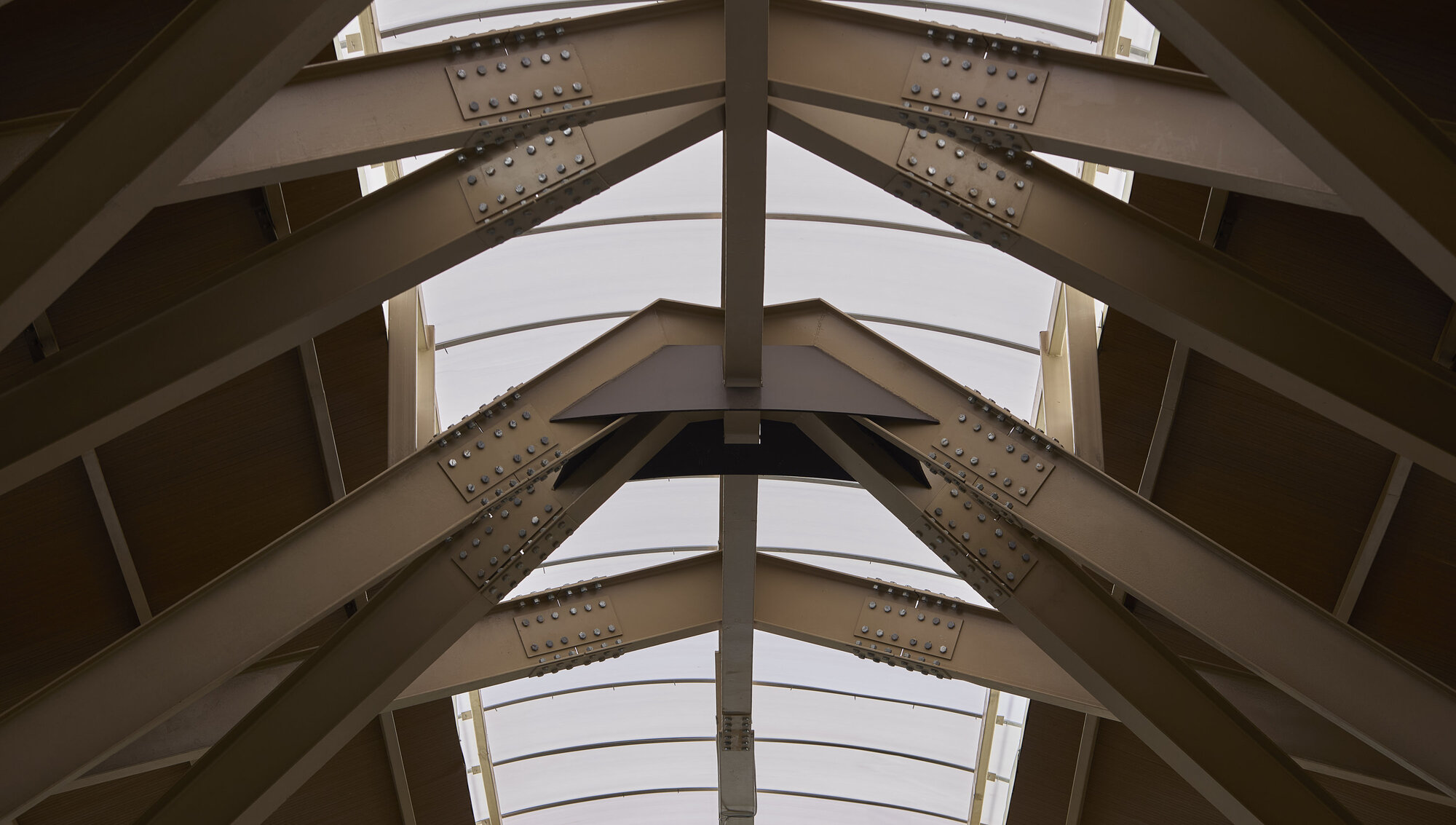 Looking up at the peaked timber roof truss and central column from below
