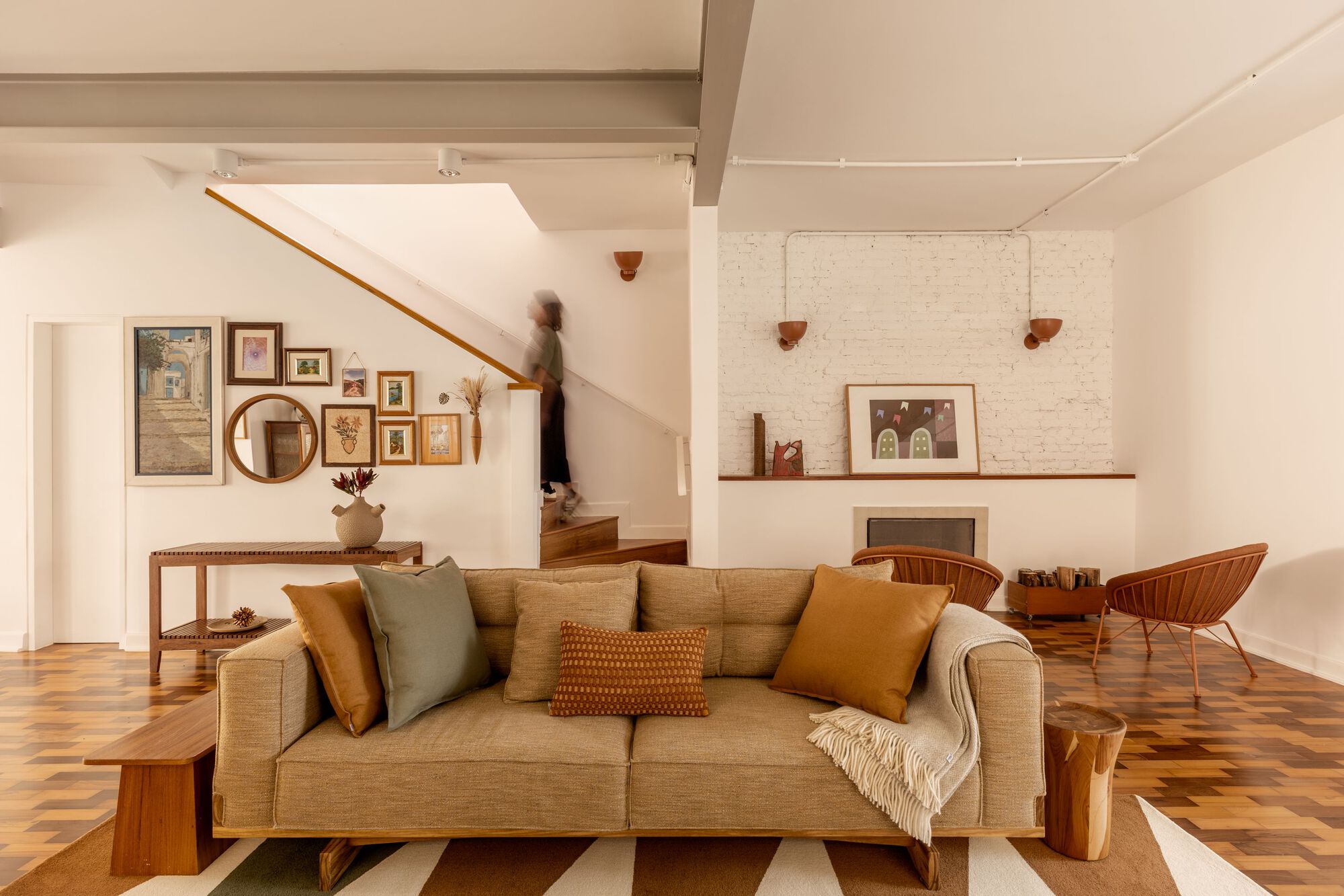 Living area showing timber stair with floating handrail and figure ascending in motion blur